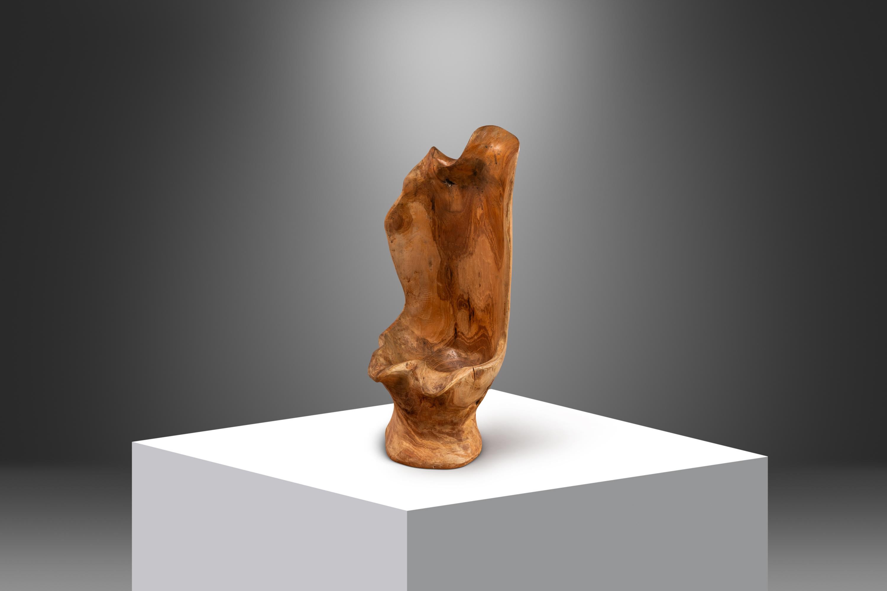 Introducing a solid teak sculpture hand-carved from a rare burlwood portion of the coveted Burmese teak tree. Burlwood results from harvesting a tree or a portion of a tree that has a burl. A burl is a growth on a tree formed from unsprouted bud