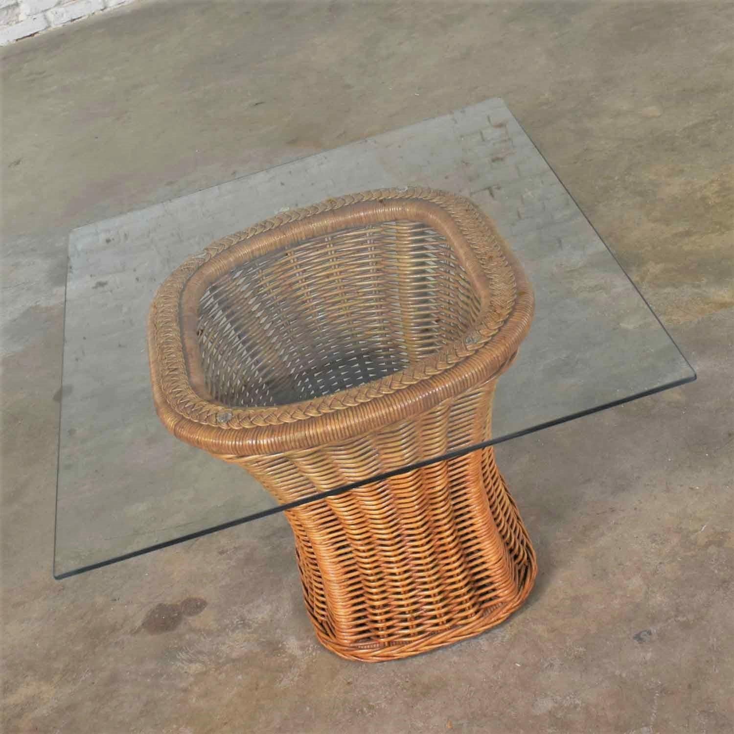 Handsome vintage organic modern woven wicker rattan end or side table fitted with a rectangular glass top. It is in wonderful vintage condition with no outstanding flaws we have detected. The glass top may have some minor scratches as you would