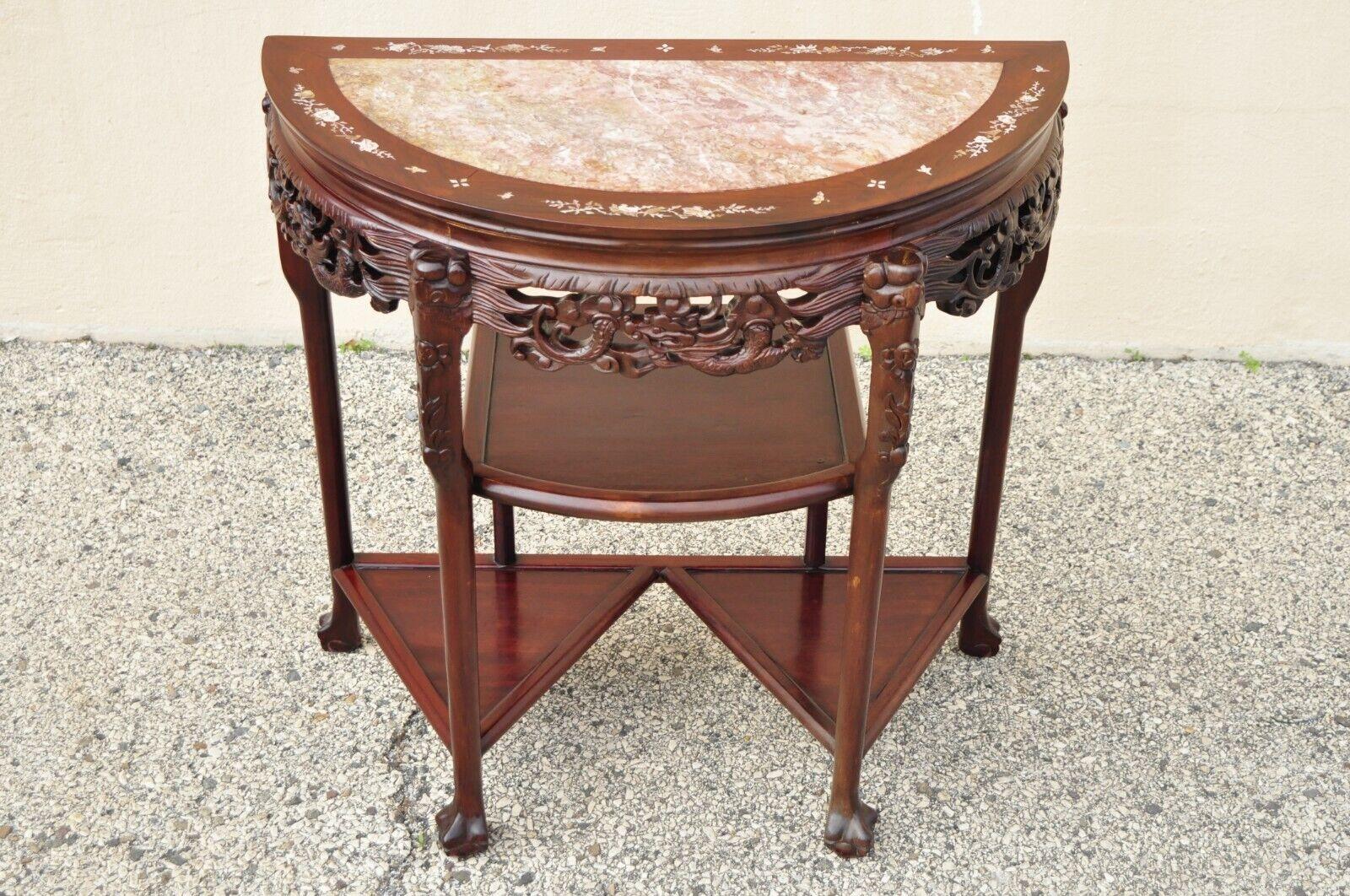 Vintage Oriental Chinese carved hardwood demilune marble top console table. Item features a half round demilune top with inset pink marble, mother of pearl flower inlay, carved ball and claw feet, multiple tiers, great style and form. Circa mid to