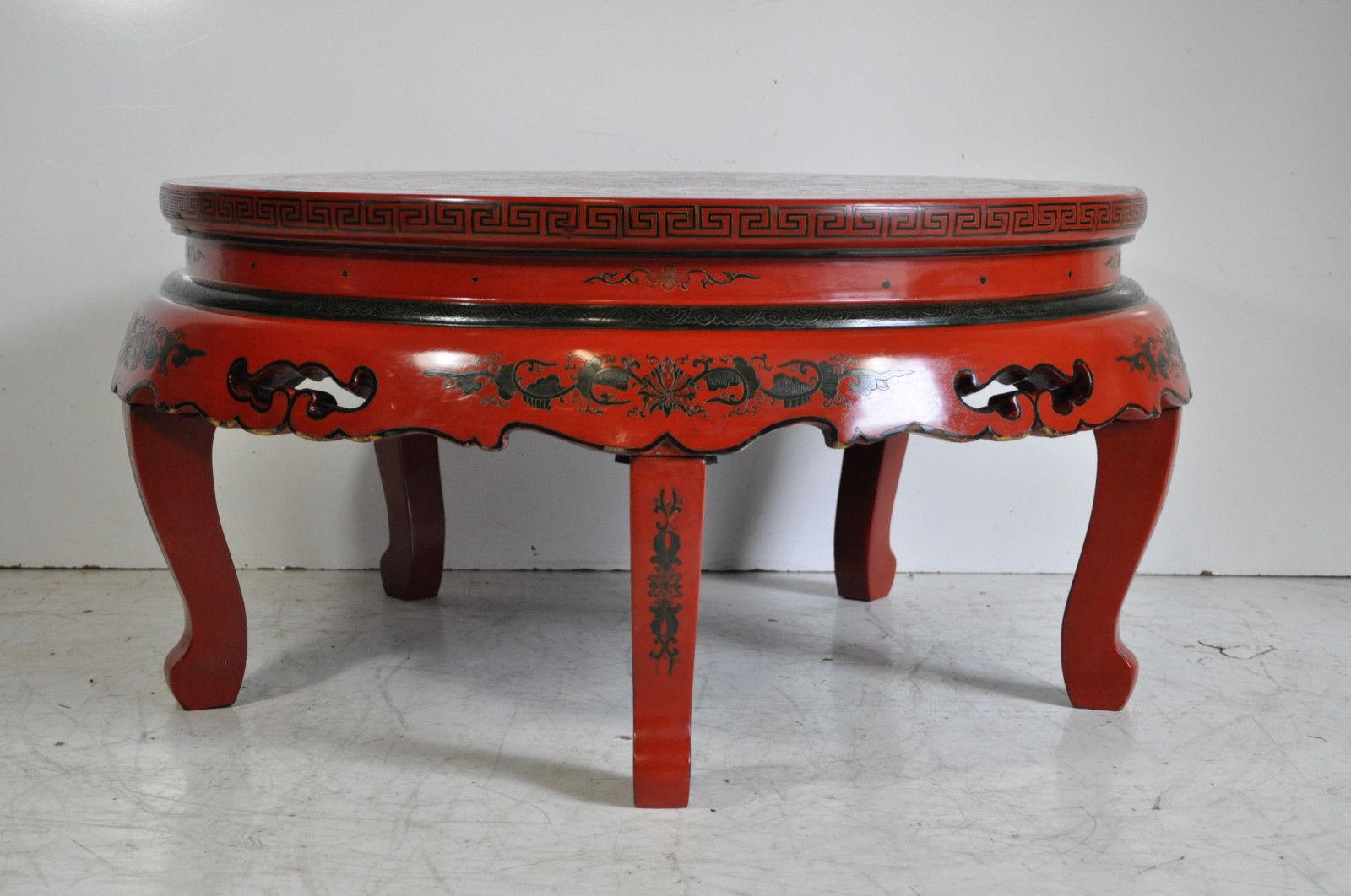 Stunning vintage red lacquer Oriental folding leg coffee table. The piece features a beautiful hand painted lacquer finish with a plethora of decorative motifs on the top, nicely carved legs and skirt, and collapsible legs for ease of storage, circa