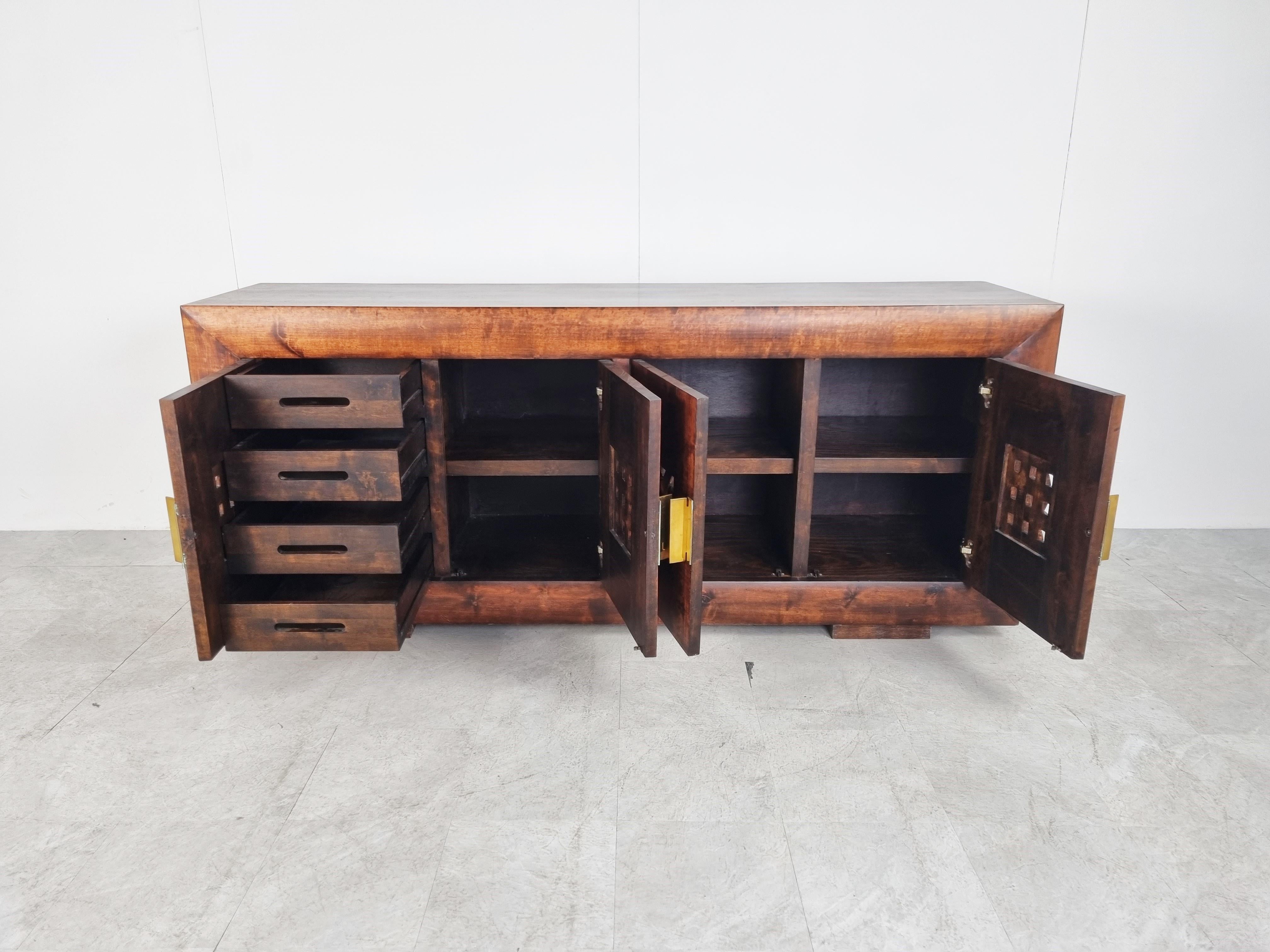Eye catching sideboard with oriental design influences.

Beautiful wood grain with nicely 'woven' wooden inserts on the doors.

The brass handles add a nice detail.

The sideboard provides plenty of storage space and has 4 integrated