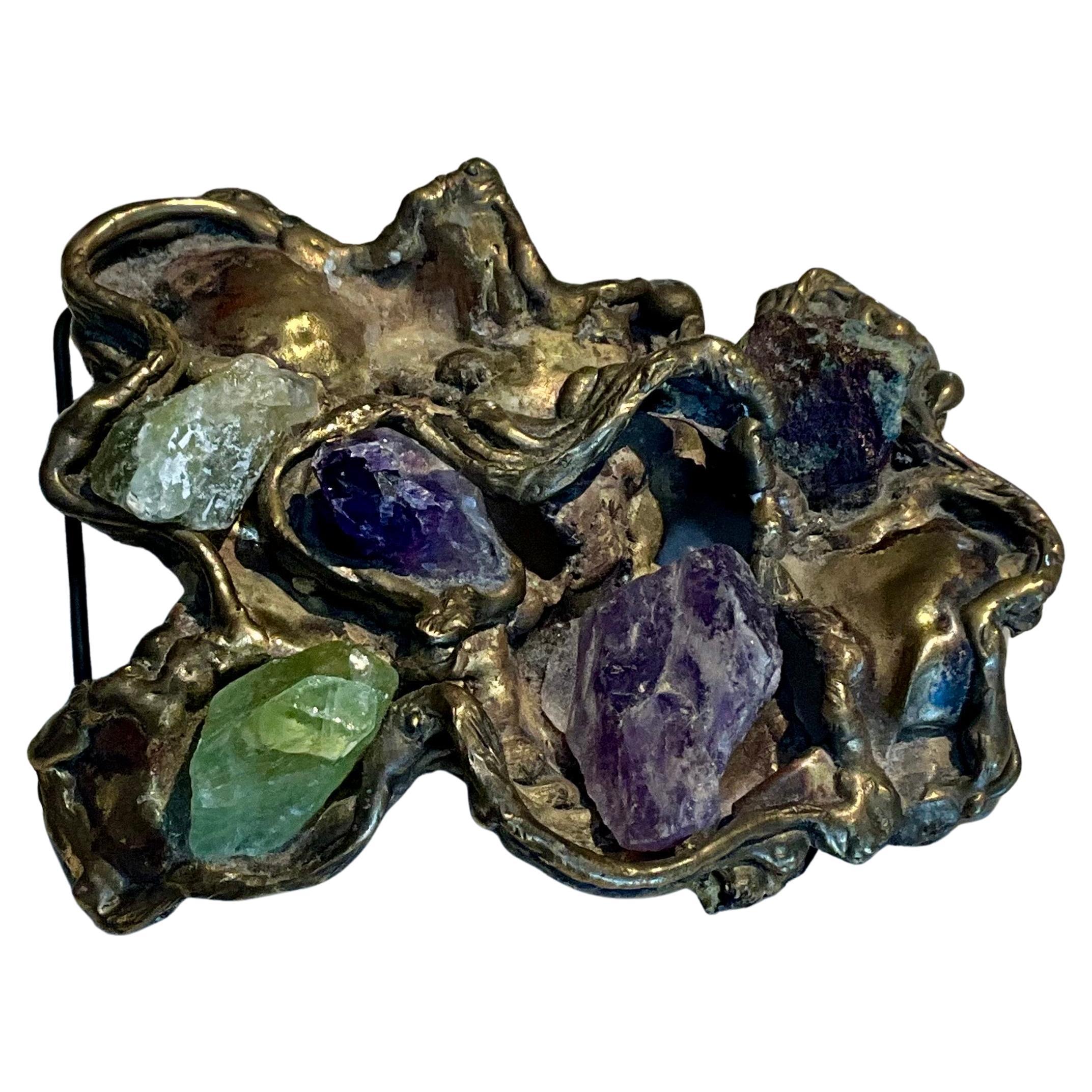 This vintage original 1960s brass belt buckle with gemstones is a stunning piece of retro jewelry that combines craftsmanship with a distinctive, bold style. Belt buckles were popular fashion accessories during the 1960s, and they often featured