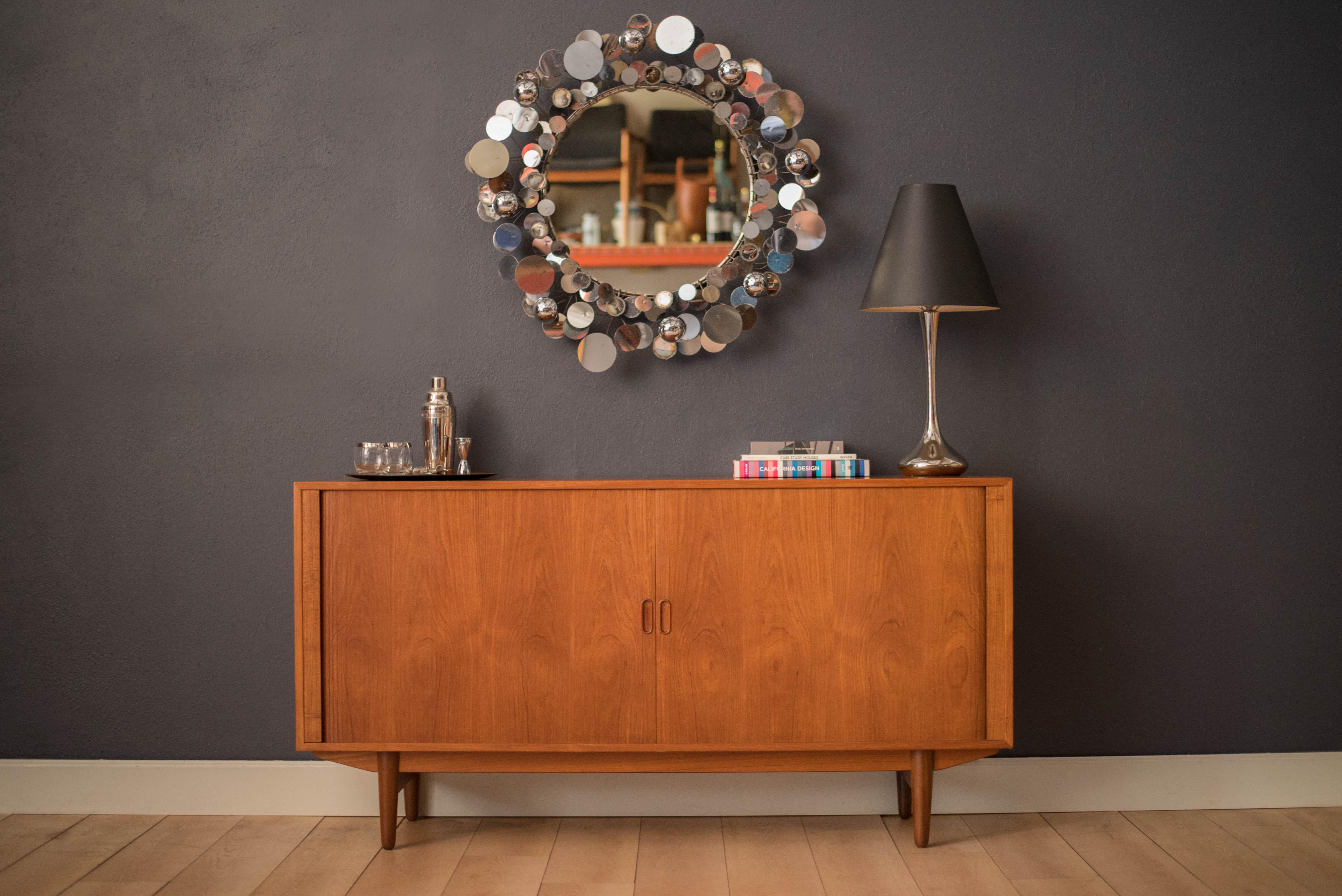 Mid-Century Modern raindrops sculpture mirror designed by Curtis Jere for Artisan House, c. 1970's. This decorative round wall mirror features reflective patterns of chrome and mixed metals with plenty of vintage patina and aged charm.


Mirror