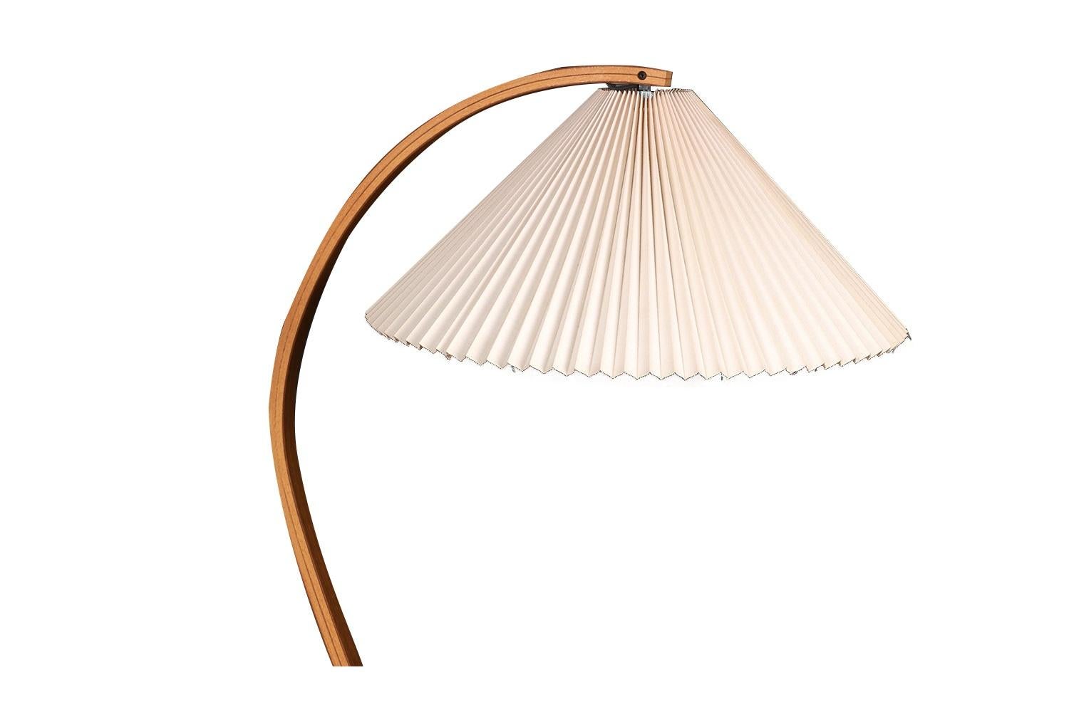 Stunning mid century original, vintage bentwood, Danish floor lamp by Mads Caprani circa 1970s. Features pleated linen shade atop dramatic curve, bentwood stand supported by a dense black, cast iron crescent-shaped base for balance, original wiring