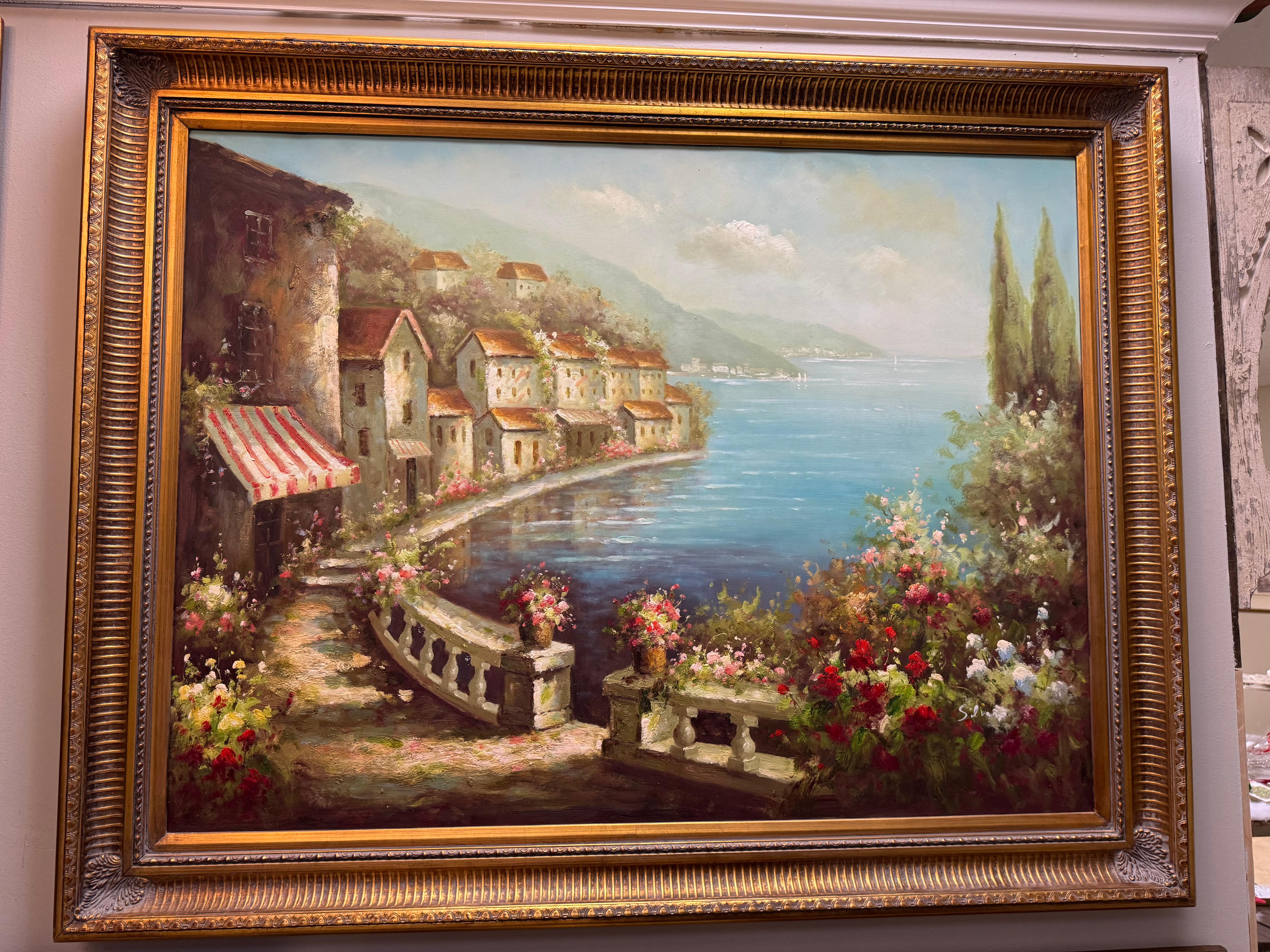 Splendido dipinto a olio su tela di un edificio sul lungomare europeo. Sembra una striscia della Rivera francese.  Incorniciato da un'ampia cornice dorata. Ha un colore fresco e una sensazione di calma per qualsiasi arredamento. Si prega di