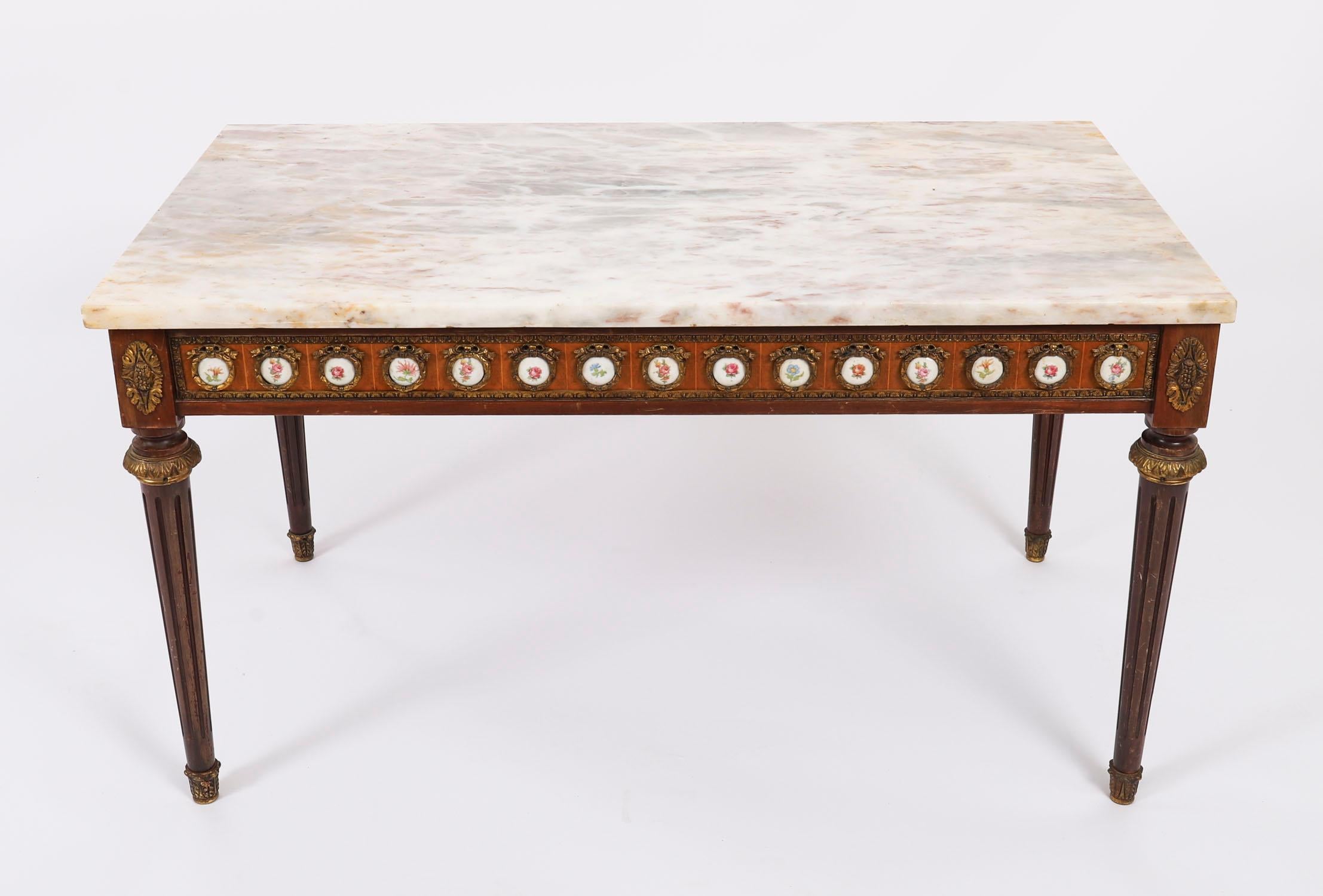 Il s'agit d'une exquise table basse continentale en noyer et marbre, datant d'environ 1950.

Cette merveilleuse table basse est de forme rectangulaire et possède quatre élégants pieds cannelés effilés. La frise présente de superbes plaques