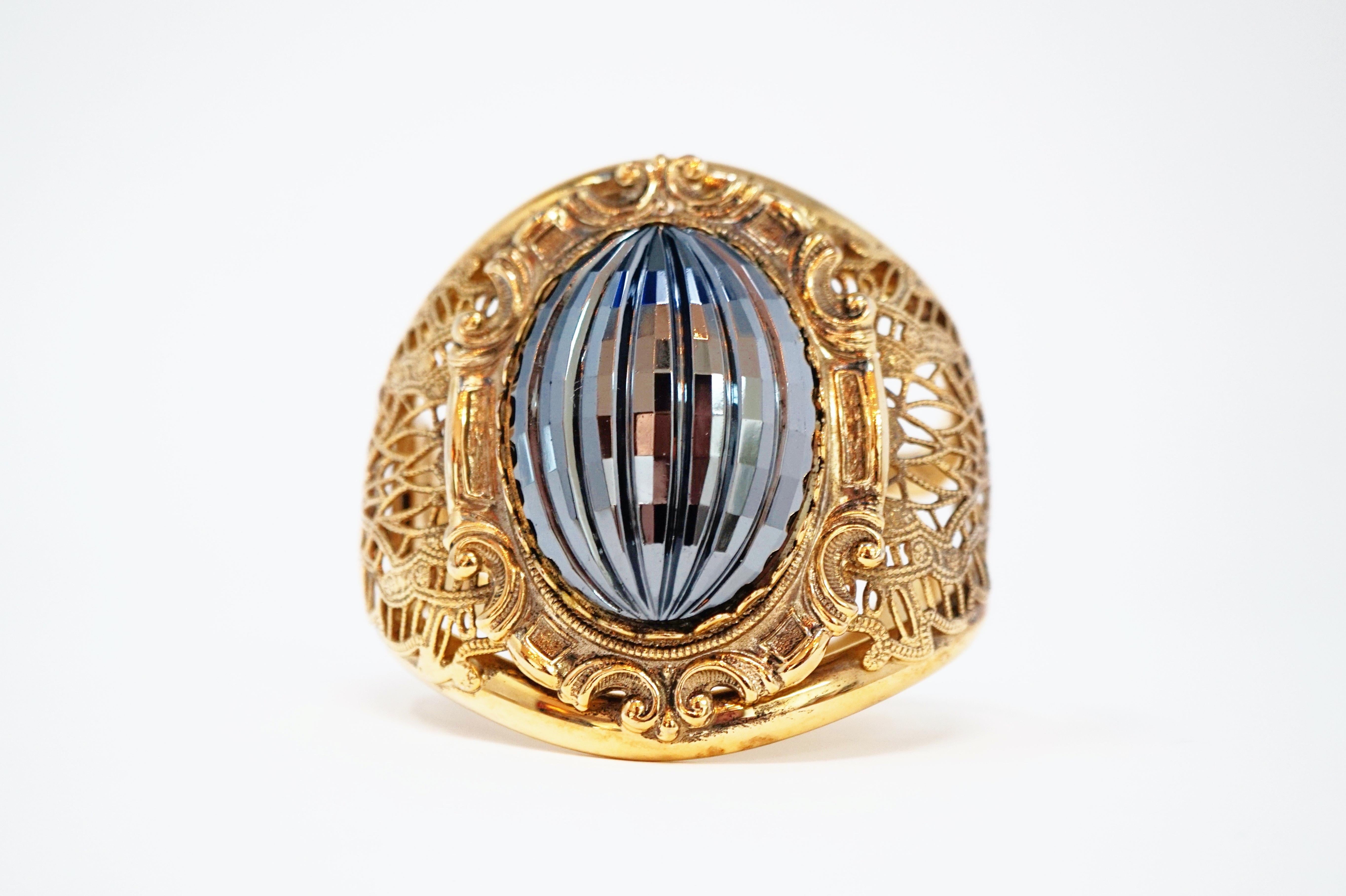 This beautiful and ornate vintage hinged cuff bracelet with large faceted faux Hematite focal cabochon is a bold and unique statement piece!  The gold tone hardware is identical to 1950s Whiting & Davis hinged clamper cuffs, but this piece is