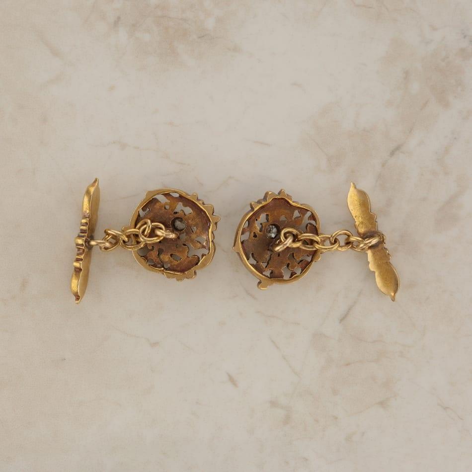 This is a pair of ornate 18ct yellow gold cufflinks. Each cufflink features a single old cut diamond in the middle of a floral pattern.

Condition: Used (Excellent)
Weight: 14.0 grams
Face Dimensions: 18mm x 18mm
Total Diamond Carat Weight: Approx.