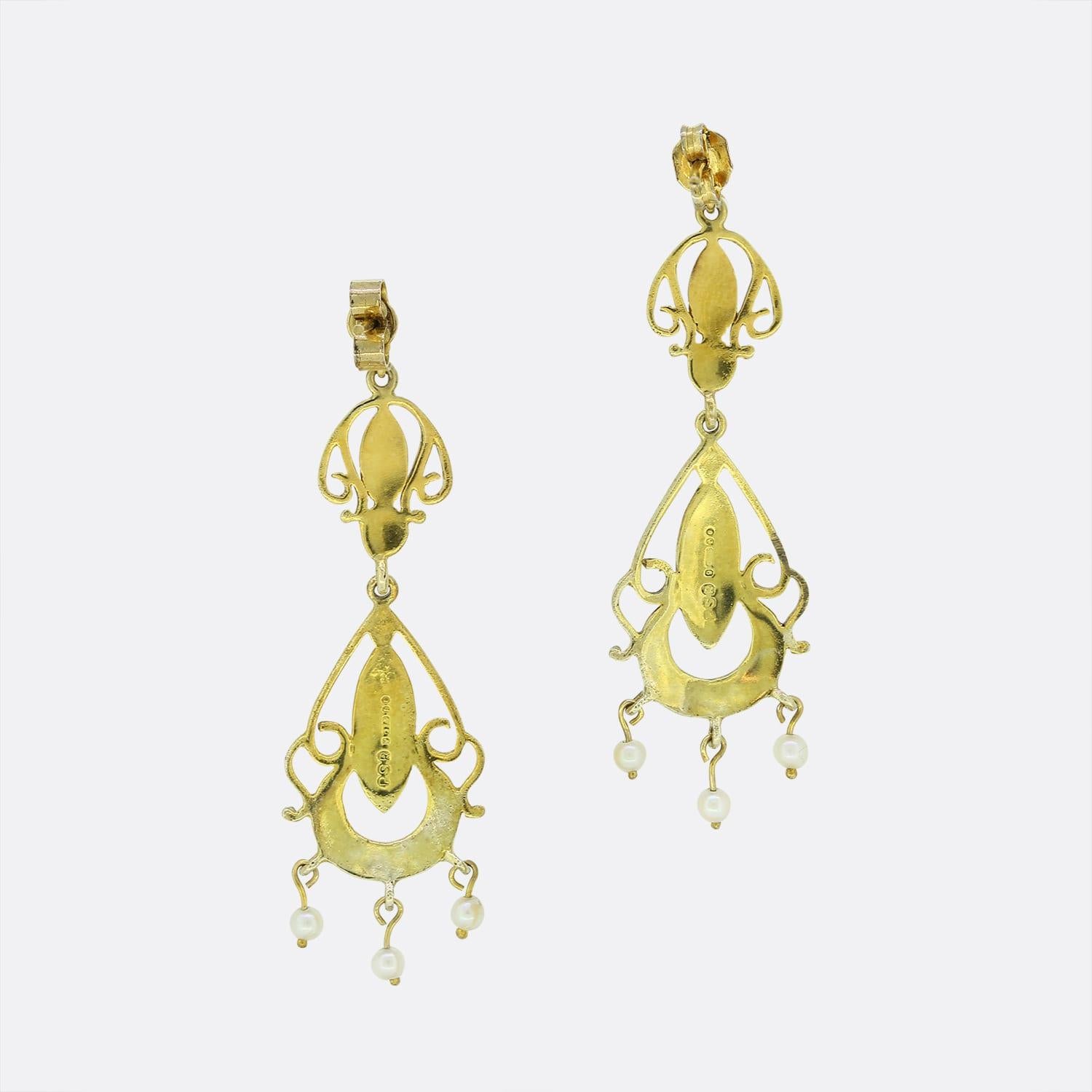 These are a pair of highly detailed vintage 9ct yellow gold pearl drop earrings. Each earring features three seed pearls which move freely when worn. The earrings also feature light blue enamel detail with secure butterfly back fittings.