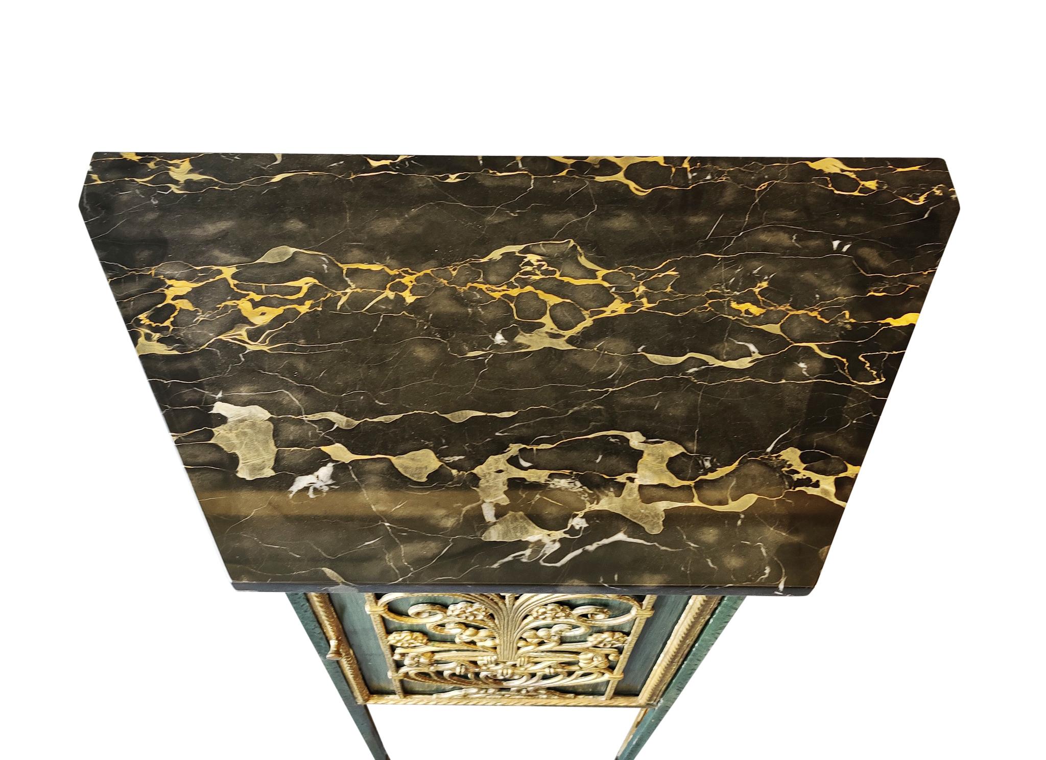 A unique bronze, iron and marble telephone stand (better use today is a bar cabinet) Attributed to New York Designer and Manufacturer, Oscar Bach. Stand has an marble top with a heavy veining and a bright finish. The door in the front has ornate