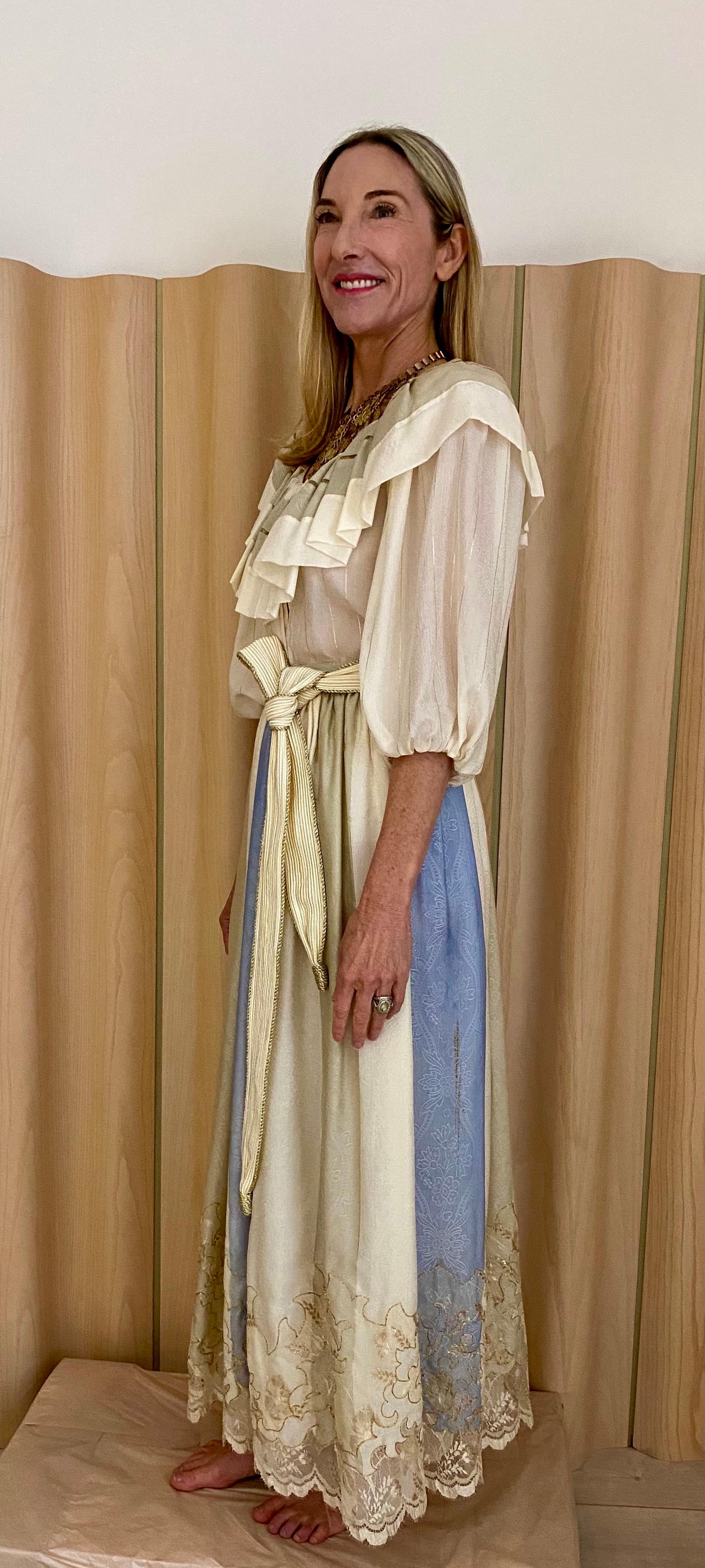 1970s Oscar de la Renta creme silk jacquard blouse and maxi skirt with blue panel and metallic thread embroidery.
Ruffle collar. Woven Belt.
Blouse measurement: Bust: 36” 
Skirt measurement: 26”/ Skirt Length: 40”

Note: There is light yellowish