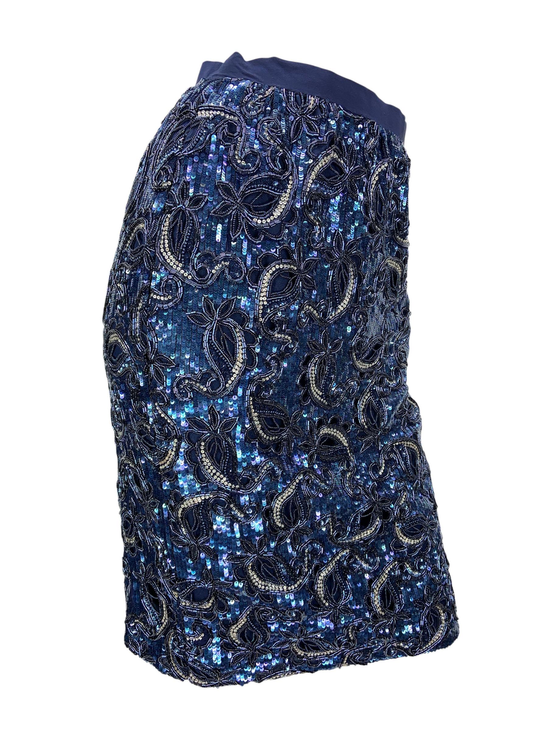 Questa gonna al ginocchio degli anni '90, creazione di Oscar De La Renta, mette in mostra la maestria artigianale e i dettagli opulenti dello stilista. Il capo è interamente impreziosito a mano da strati di paillettes scintillanti di colore blu che