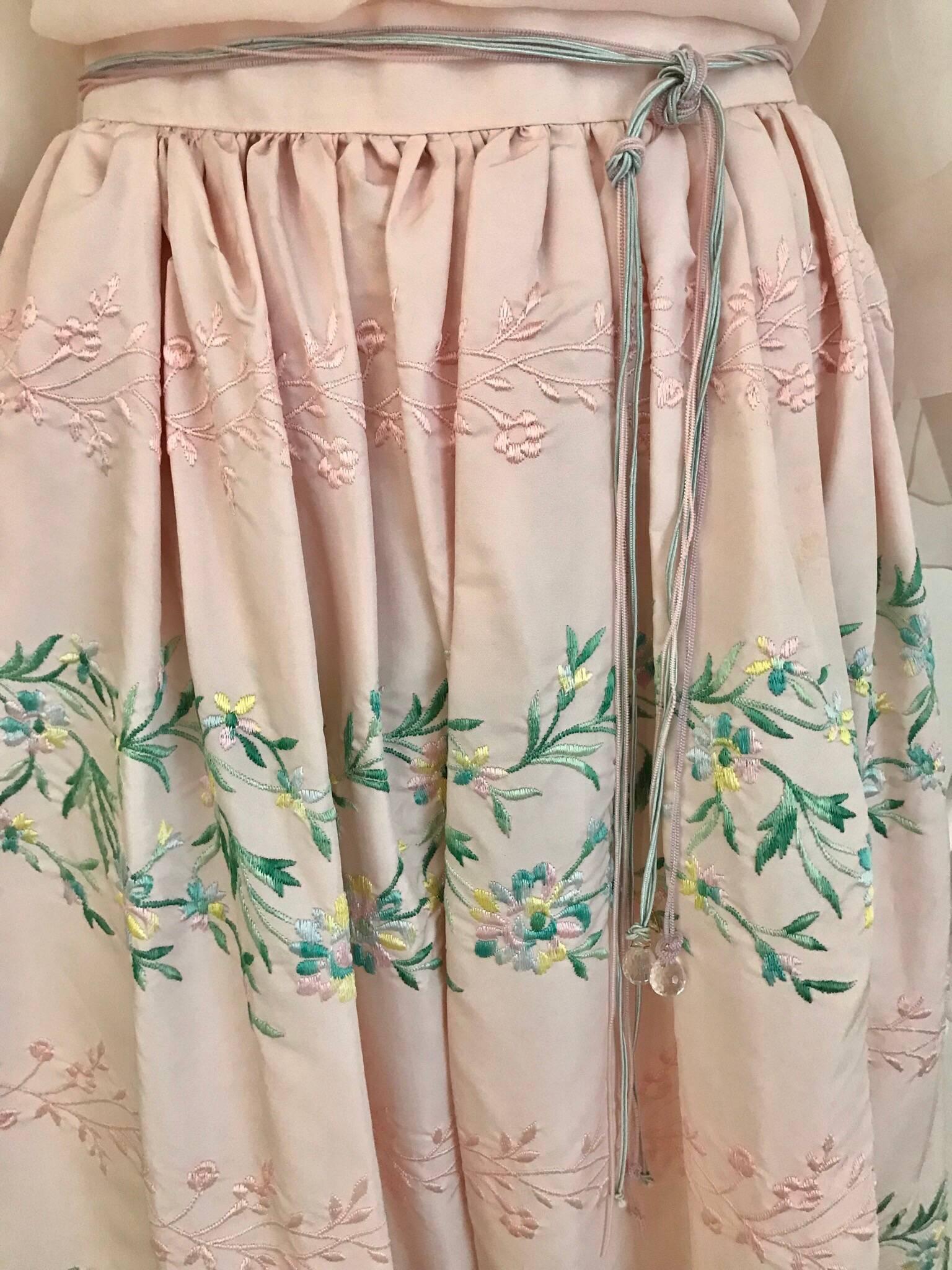 This 1980s Oscar de LaRenta peasant blouse with matching embroidered skirt is the perfect blend of casual, sexy and elegant. The blouse can be worn on shoulder, off shoulder or one shoulder. The heavy silk skirt has beautiful detailed embroidery of