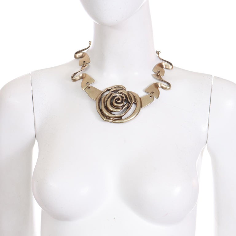 This is a lovely Oscar de la Renta statement necklace with a large central cutout rose. This wonderful necklace has wavy links and a long adjustable chain in back. This piece has a hand-forged brutalist look and feel, with a dappled underside and a