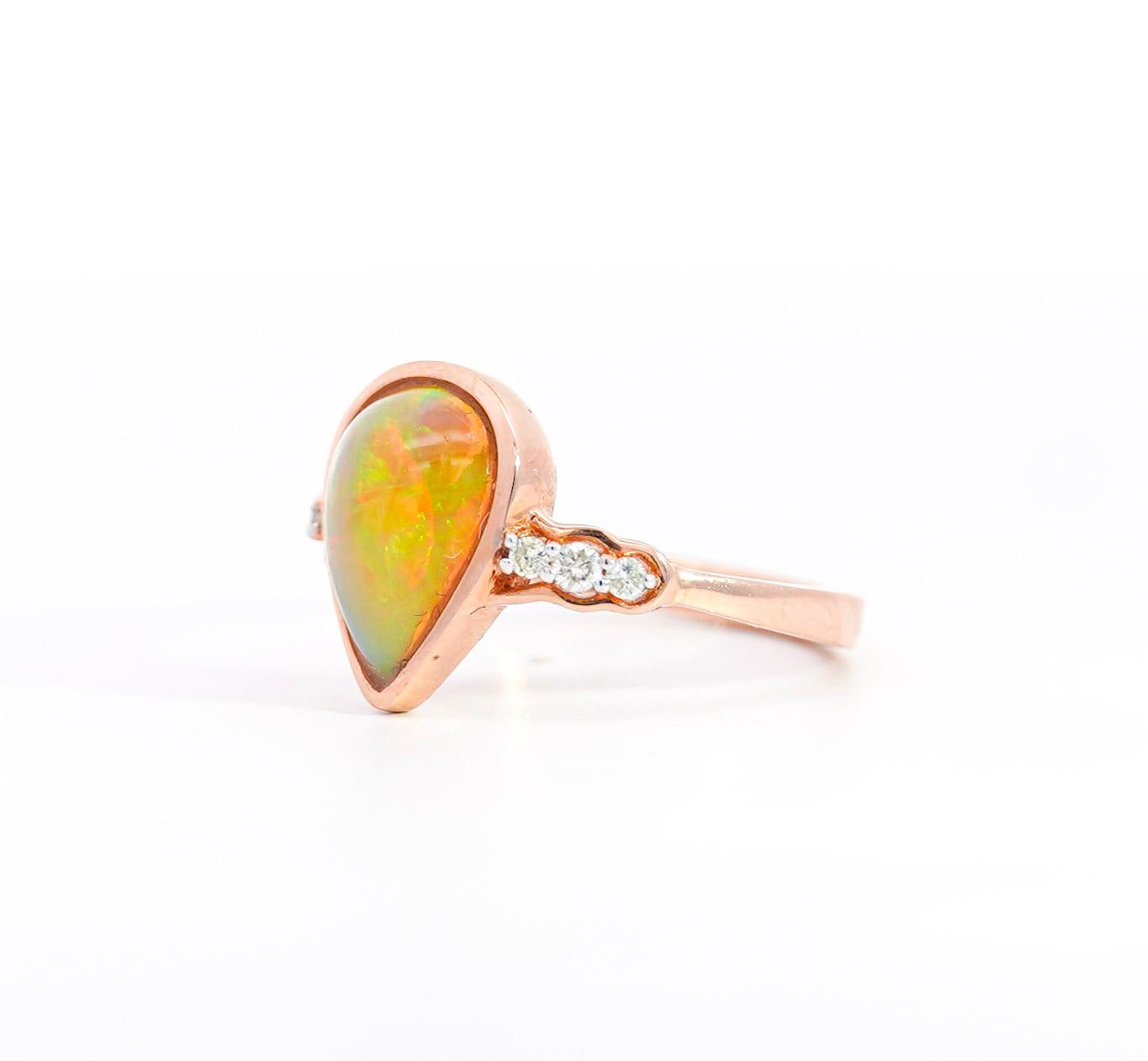 Vintage cabochon cut pear-shaped opal and diamond ring. Set in a 14K rose gold setting, weighing 3.3 grams, ring size 6.75 (adjustable). The Opal featured a magnificent array of iridescent colors that can only be found fo the finest natural