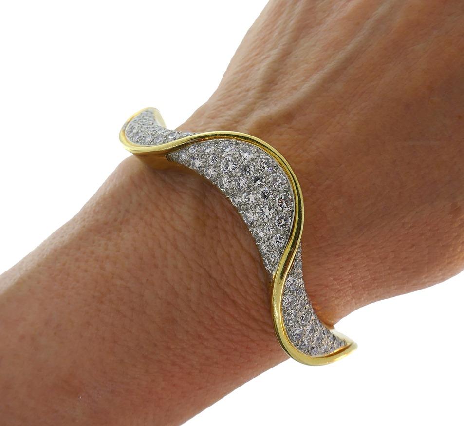 Feminine and timeless bangle bracelet created by Oscar Heyman in the 1980s. Elegant and wearable, the bangle is a great addition to your jewelry collection. 
Made of 18 karat (stamped) yellow gold and set with round brilliant cut diamonds (F-G