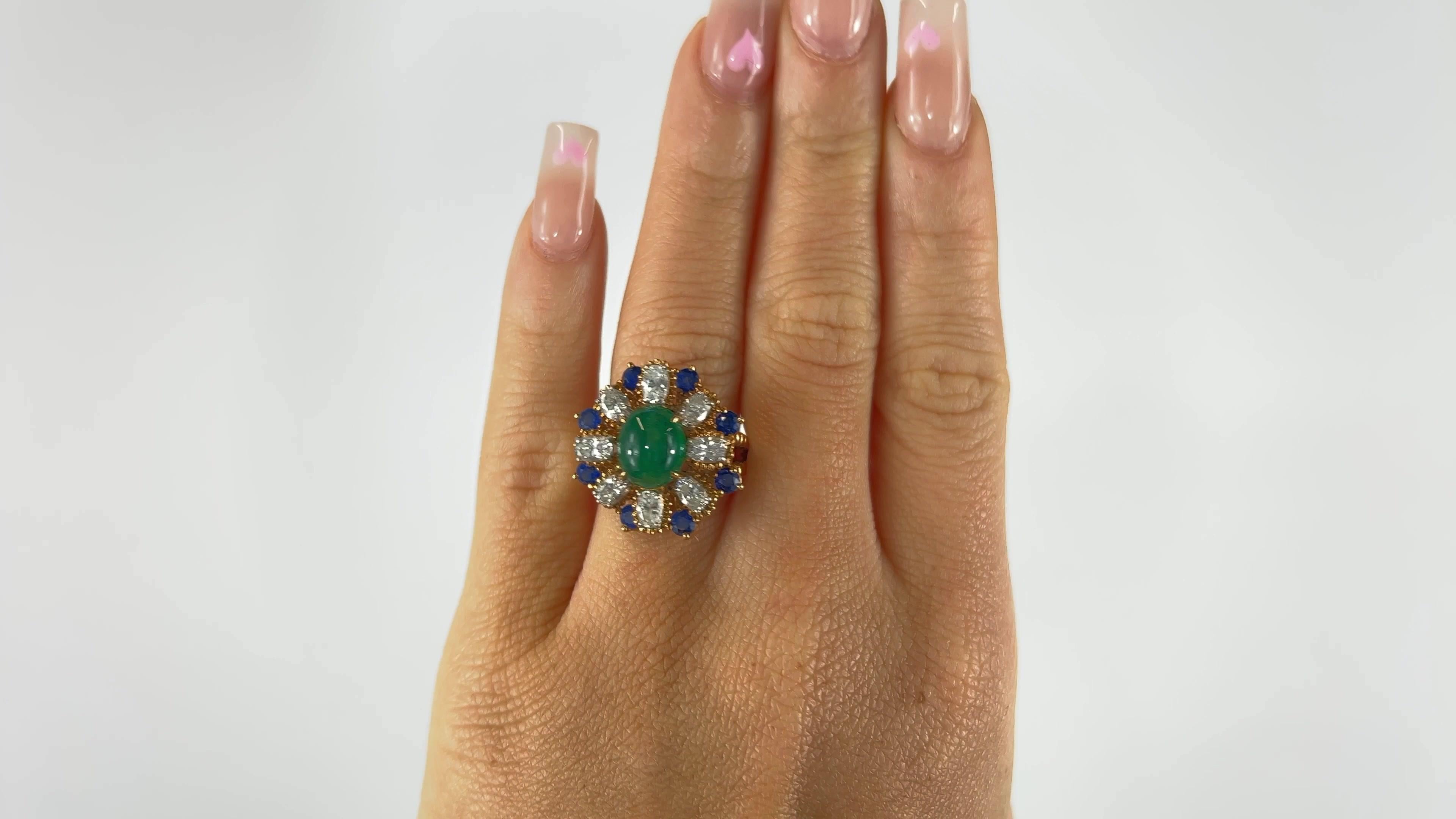One Vintage Oscar Heyman Emerald Diamond Sapphire Cluster Cocktail Ring. Featuring one cabochon cut emerald of approximately 3.00 carats. Accented by eight oval cut diamonds with a total weight of approximately 2.00 carats, graded E-F color, VS