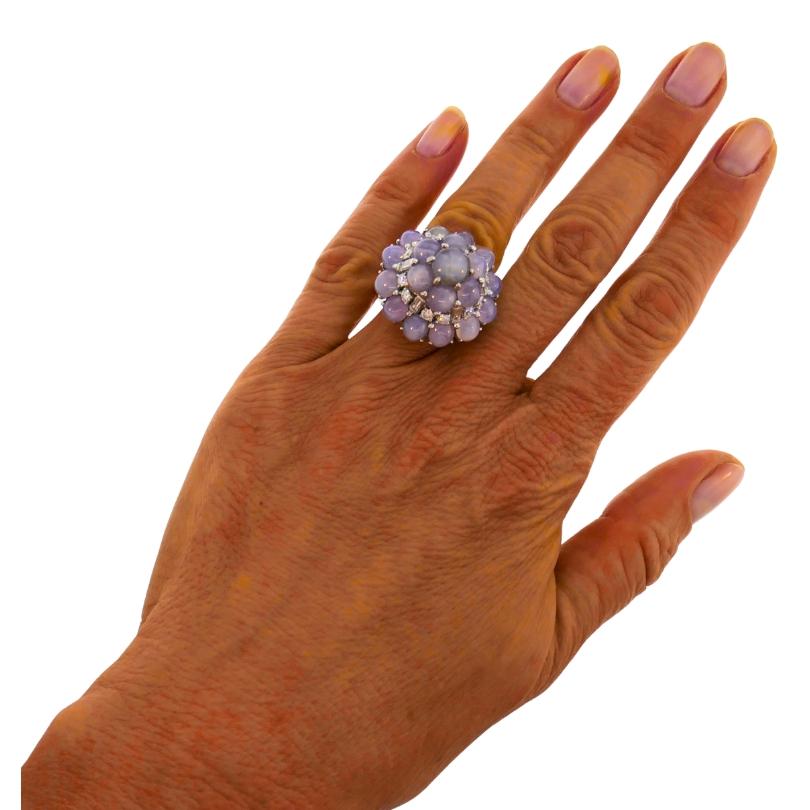An Oscar Heyman star sapphire diamond cluster platinum ring.
The ring features a striking combination of star sapphires (total weight is 25.45 carats), round brilliant and baguette cut diamonds (total weight is 1.68 carats), creating a beautifully