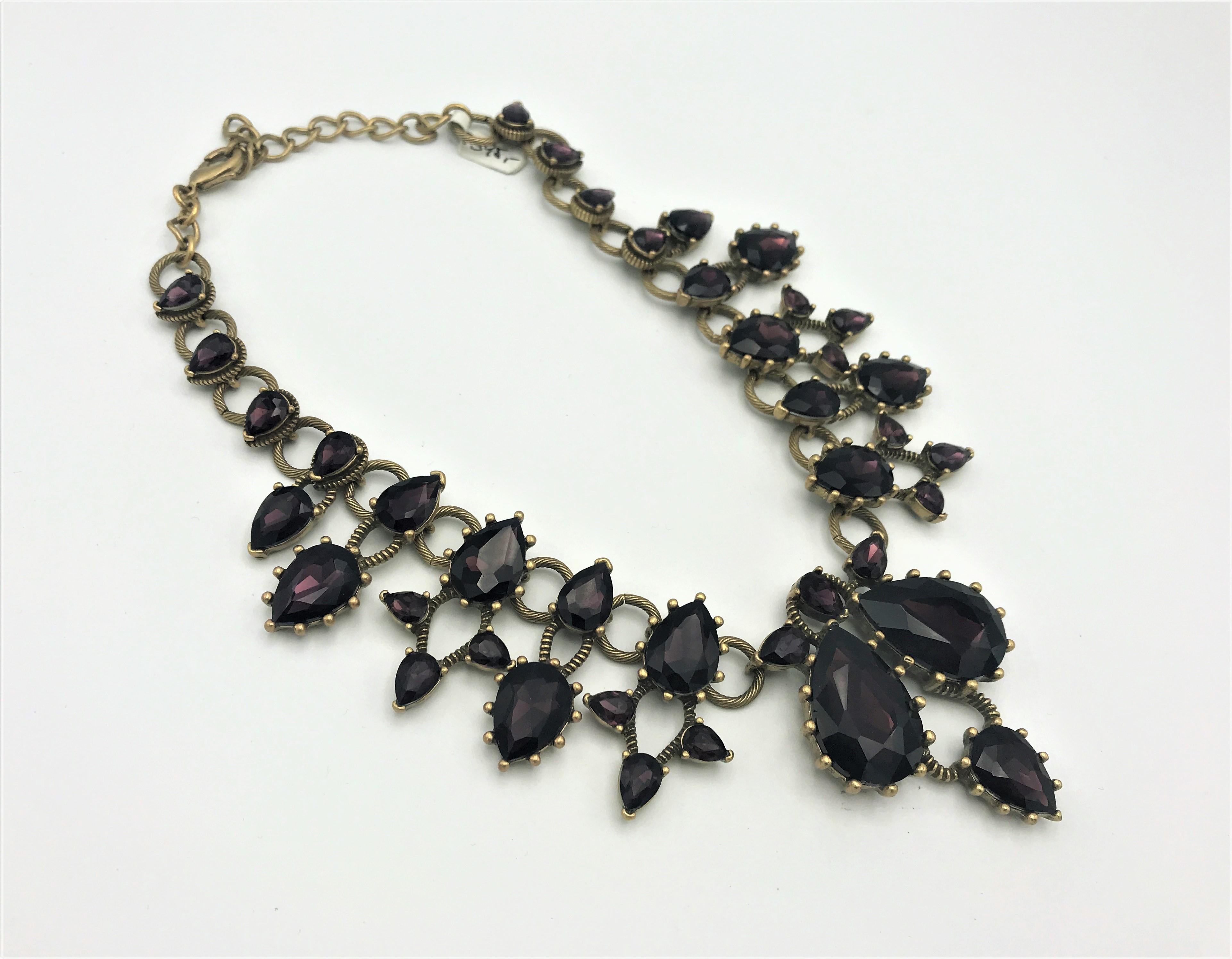 Brass Vintage Oscar De La Renta featuring with large to small cut purple glas stones in teardrop shape set in Brass. A wonderful statement collar that will transcend the season perfectly.
Length 48 cm  
Width in the middle 6 cm  
Size of the 2