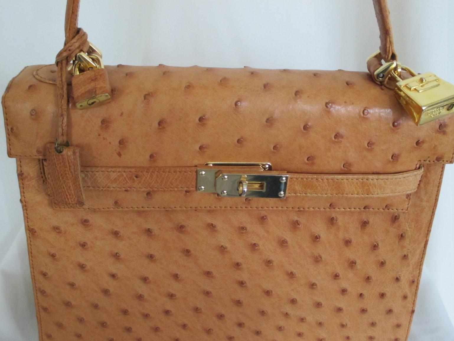 Rare vintage ostrich leather Kelly style handbag. 
Handmade by Cape Cobra, leather luxury goods.
This bag is made of cognac color ostrich leather with gold hardware and a front closure.
The lining has 1 zip pocket and 2 pockets.
This outside is in
