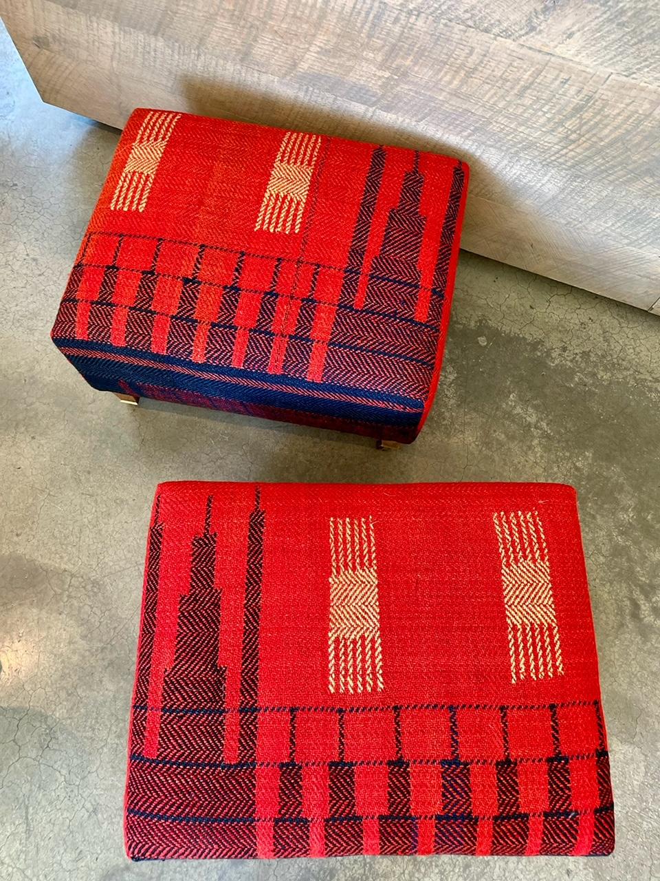 Nous adorons ce remarquable ottoman vintage avec des pieds en bois et des roulettes en laiton. Il a été récemment recouvert d'un riche textile rouge tissé à la main, avec des touches de bleu marine et de crème, et constitue une parfaite touche de