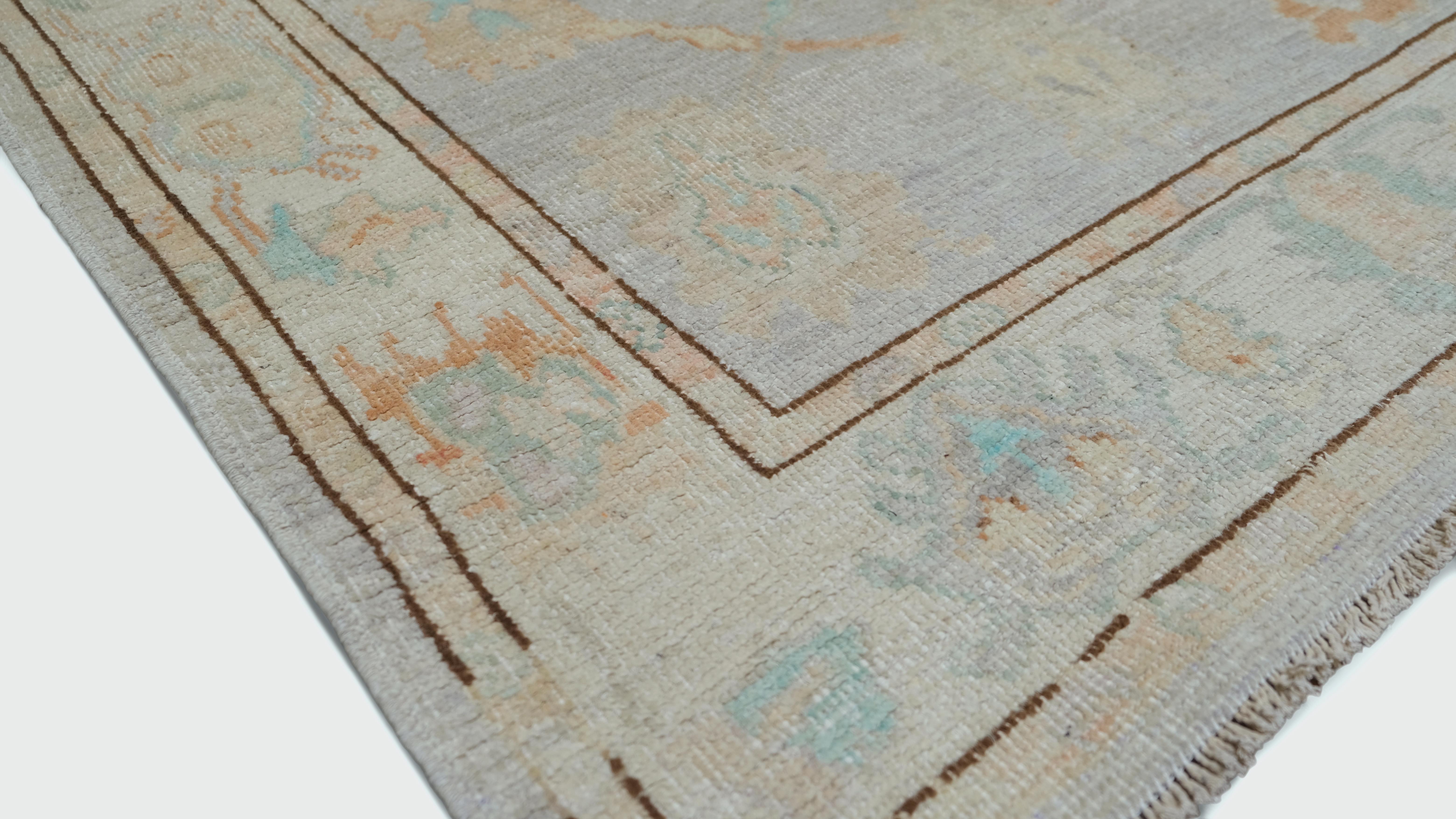 Enhance your home with this exquisite hand-knotted wool rug, featuring a timeless vintage-inspired design. The rug showcases an elegant floral motif. A delicate border frames the central pattern, adding definition and a touch of
