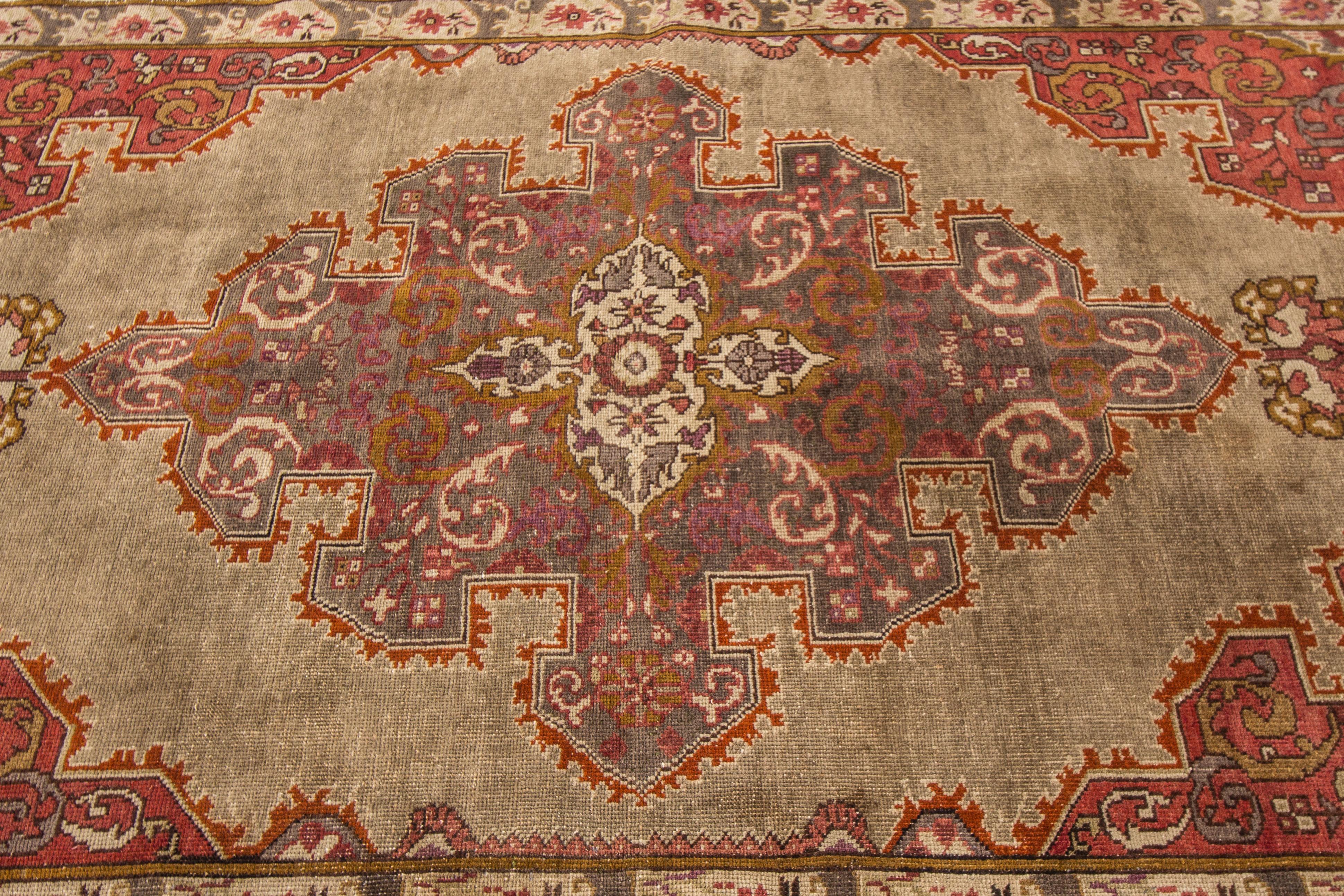 A hand-knotted vintage Oushak rug with a medallion design. This piece has great detailing and colors. It would be the perfect addition to your home. Measures: 7'4