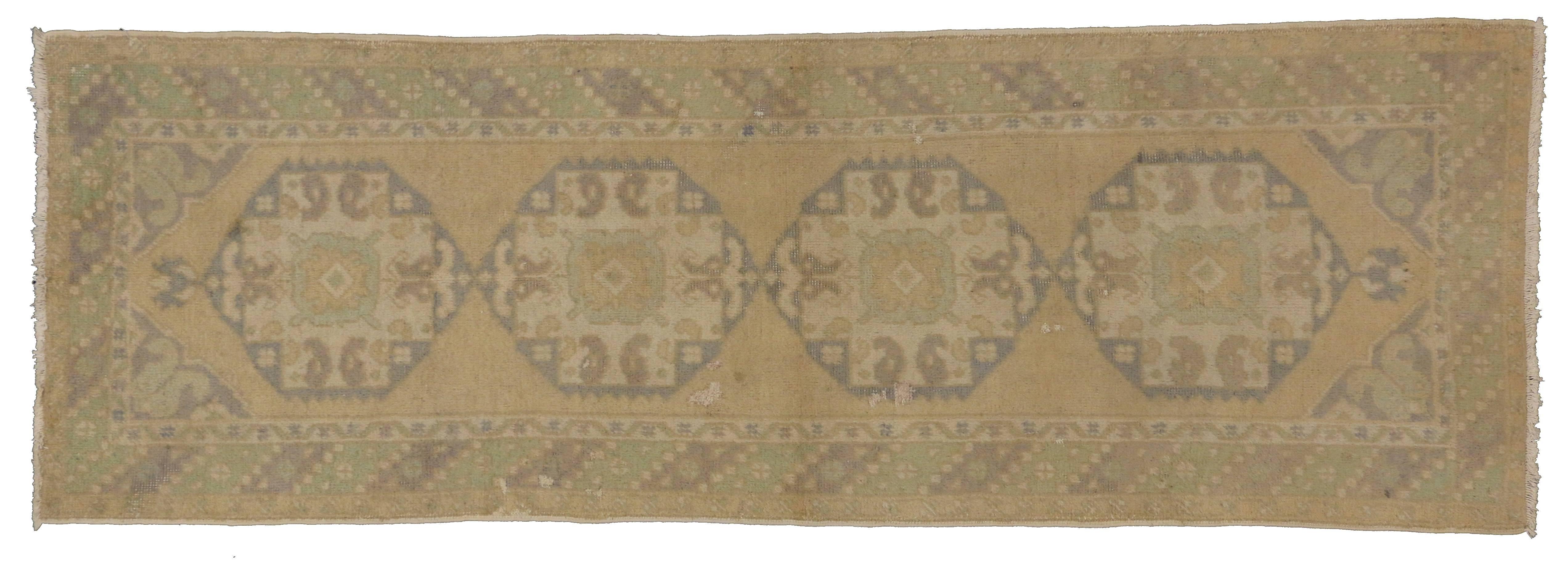 74127, vintage Turkish Oushak carpet runner with soft colors. This hand-knotted wool vintage Oushak runner features four hexagonal amulets anchored with lotus. Each amulet has a mint tribal symbol to the center with floating boteh. The amulets are