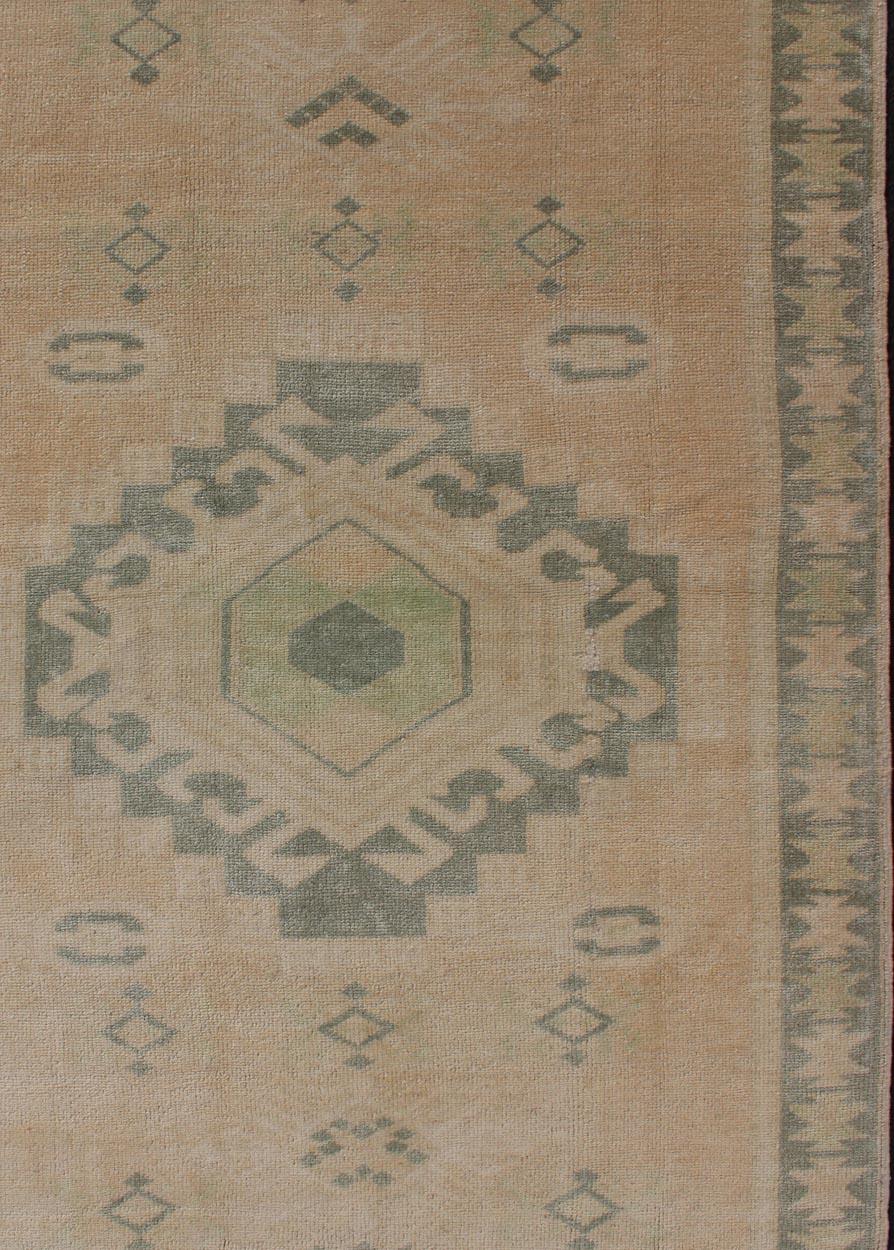 Vintage Oushak rug with central medallion warm green tones and earthy tones, Keivan Woven Arts / Rug TU-MTU-107, country of origin / type: Turkey / Oushak, circa mid-20th century.

This vintage Turkish Oushak rug (circa mid-20th century) features