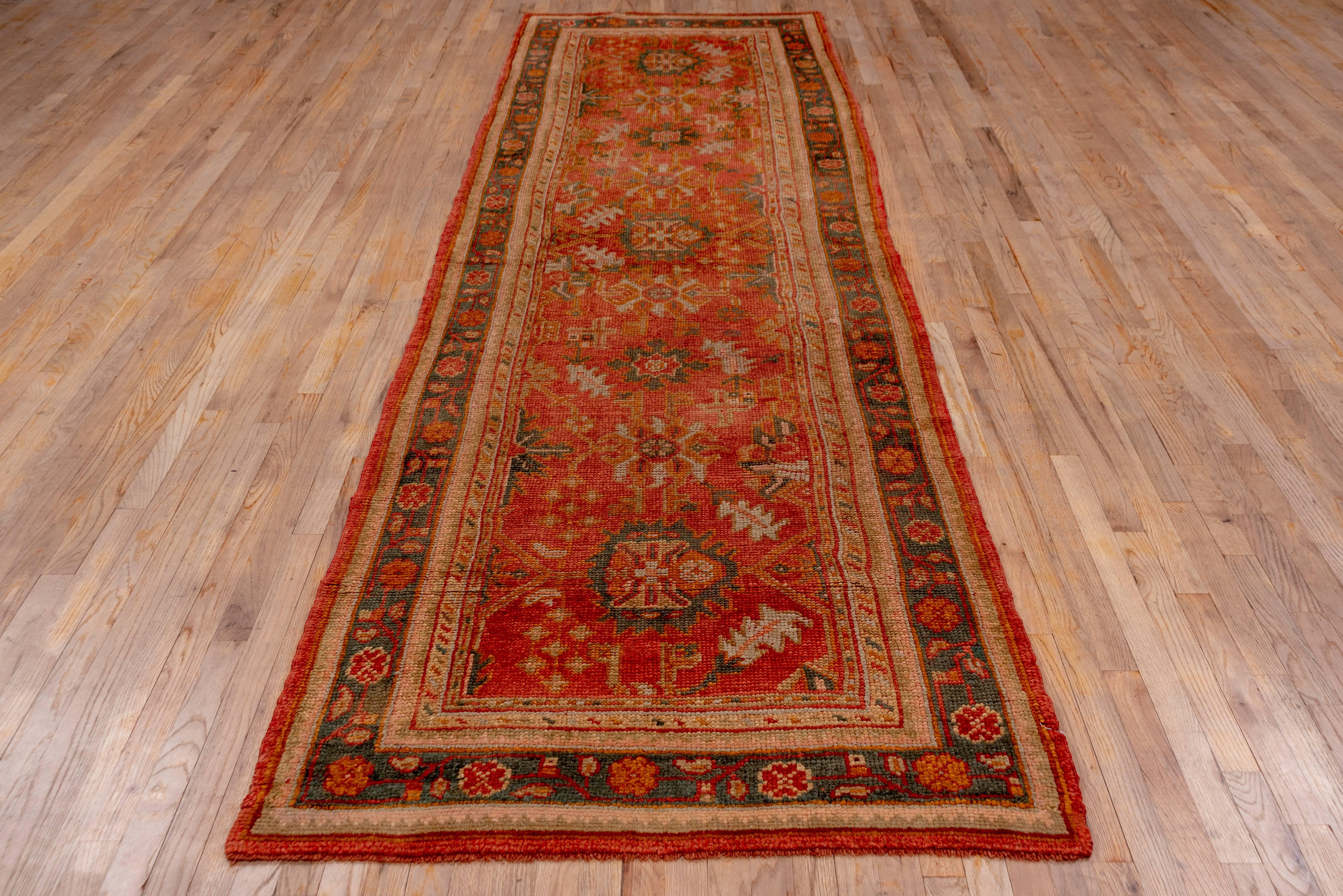 This vintage 1920s Oushak runner has been woven in a village setting by an experienced weaver. At first glance, it may seem the pattern is somewhat random but is actually well balanced. Complimenting the design with an understated palette makes a