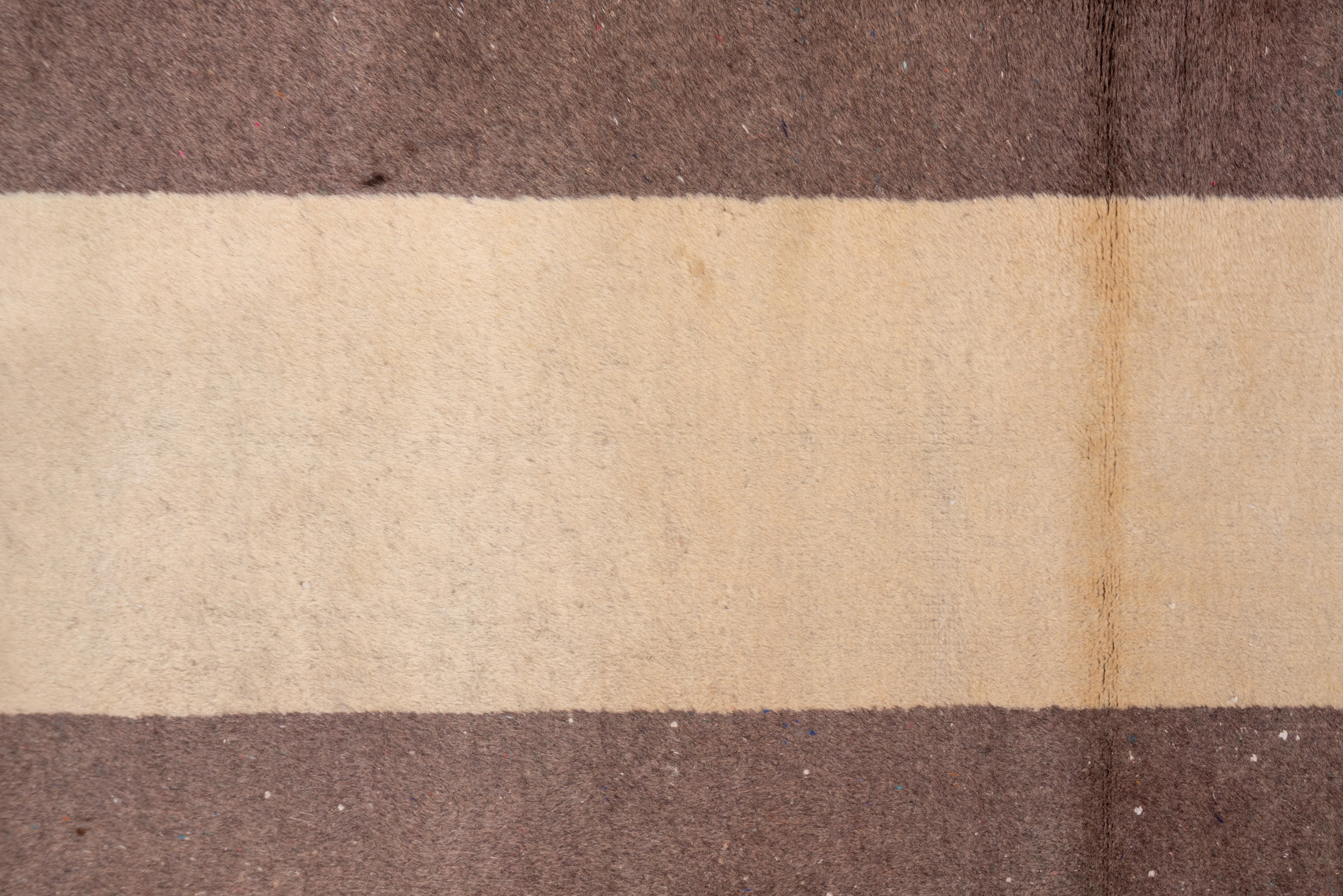 This vintage Oushak runner embraces a minimalist aesthetic with bold vertical stripes in earthy brown and warm ivory. The simplicity of the design highlights the natural wool texture and subtle tonal variations, giving the piece a refined, organic