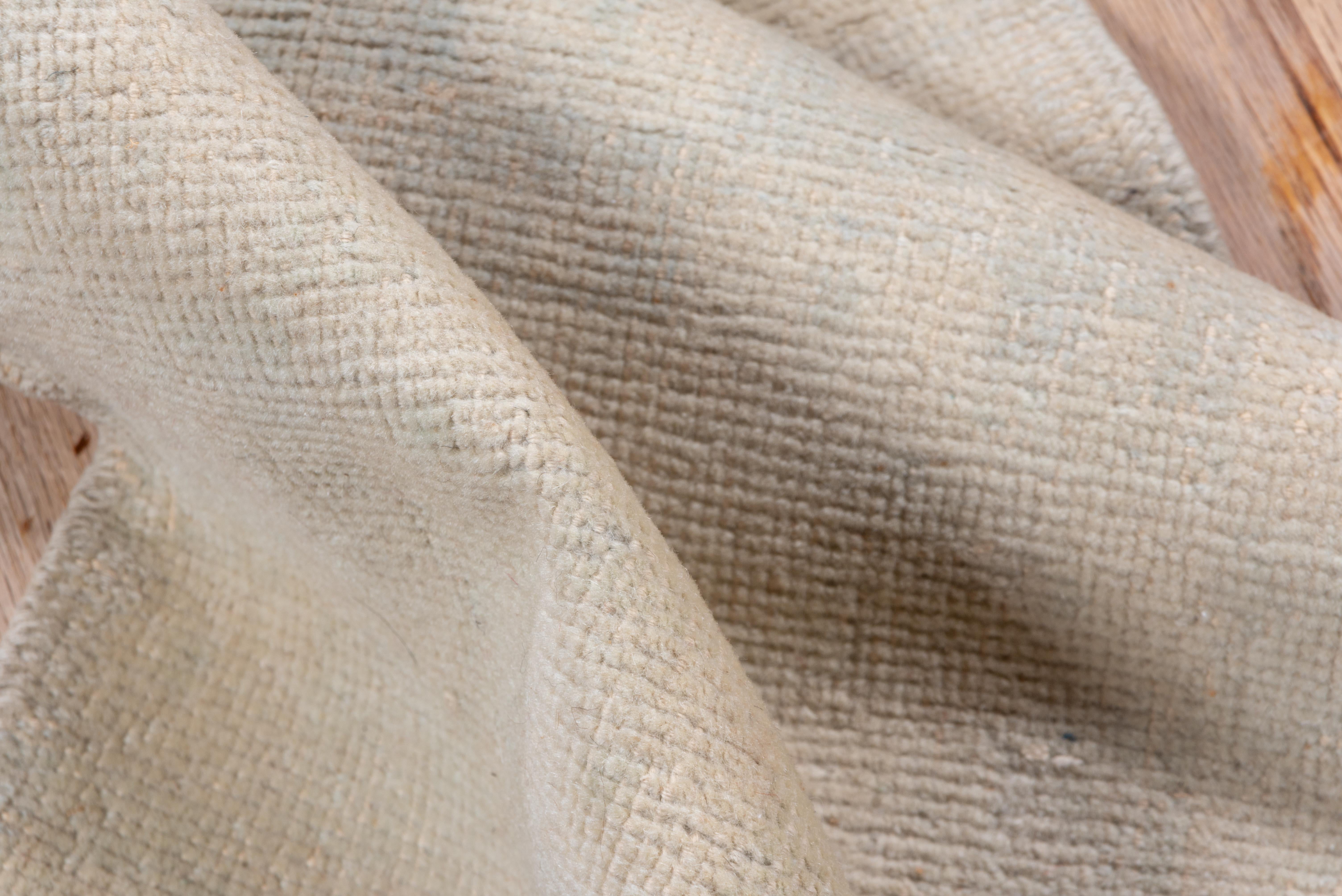 This vintage Oushak runner features a softly rendered checkerboard pattern in warm ivory and cream tones, creating a tone-on-tone effect that feels both elegant and understated. The minimalist design allows the natural wool texture and nuanced color