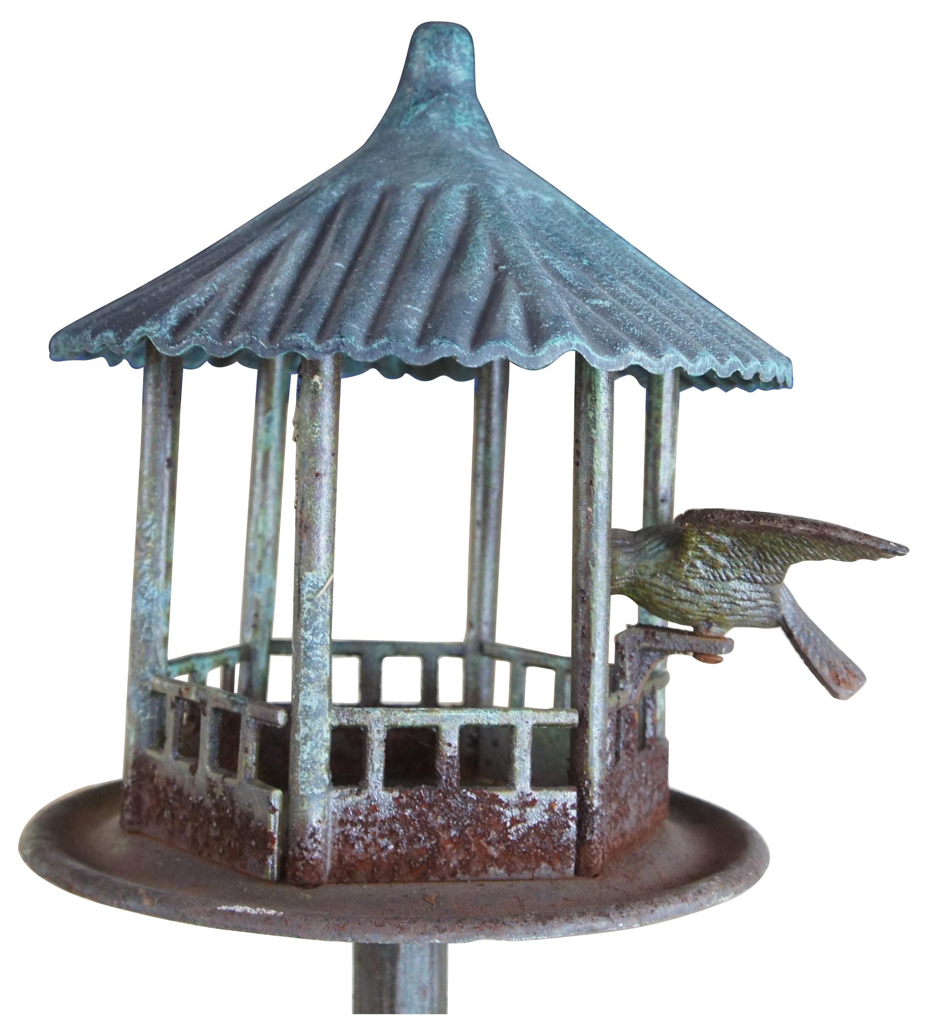 A unique vintage cast iron bird feeder. Features a gazebo with bird over a long post. Measure: 54
