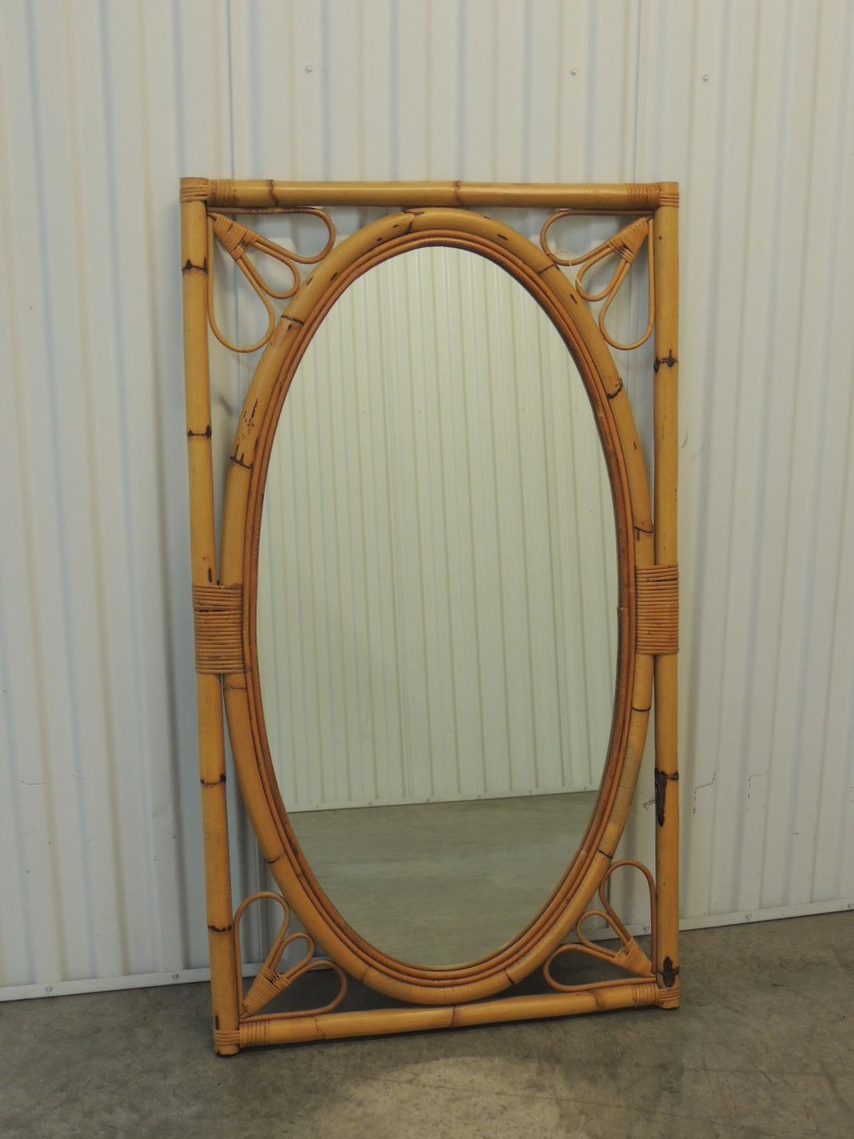 Vintage oval bamboo and rattan mirror on rectangular frame.
Hanging wire in the back.
Size: 24.5
