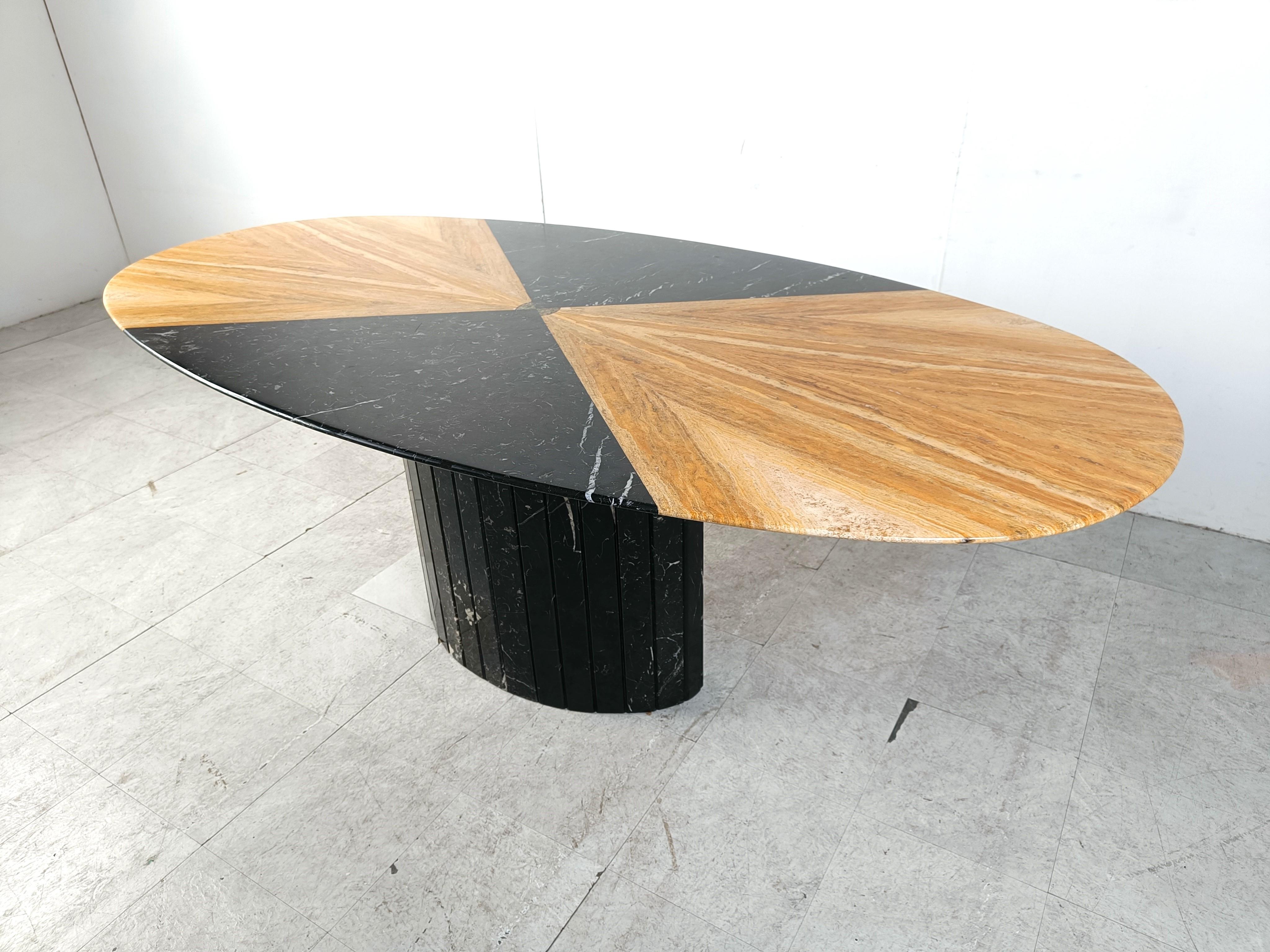 Unique and elegant marble dining table with a reeded central base. 

The table table is made of black marble and onyx and at the center we find a glass and resin detail.

Beautiful veined marble.

Timeless and very beautiful table wich fits most