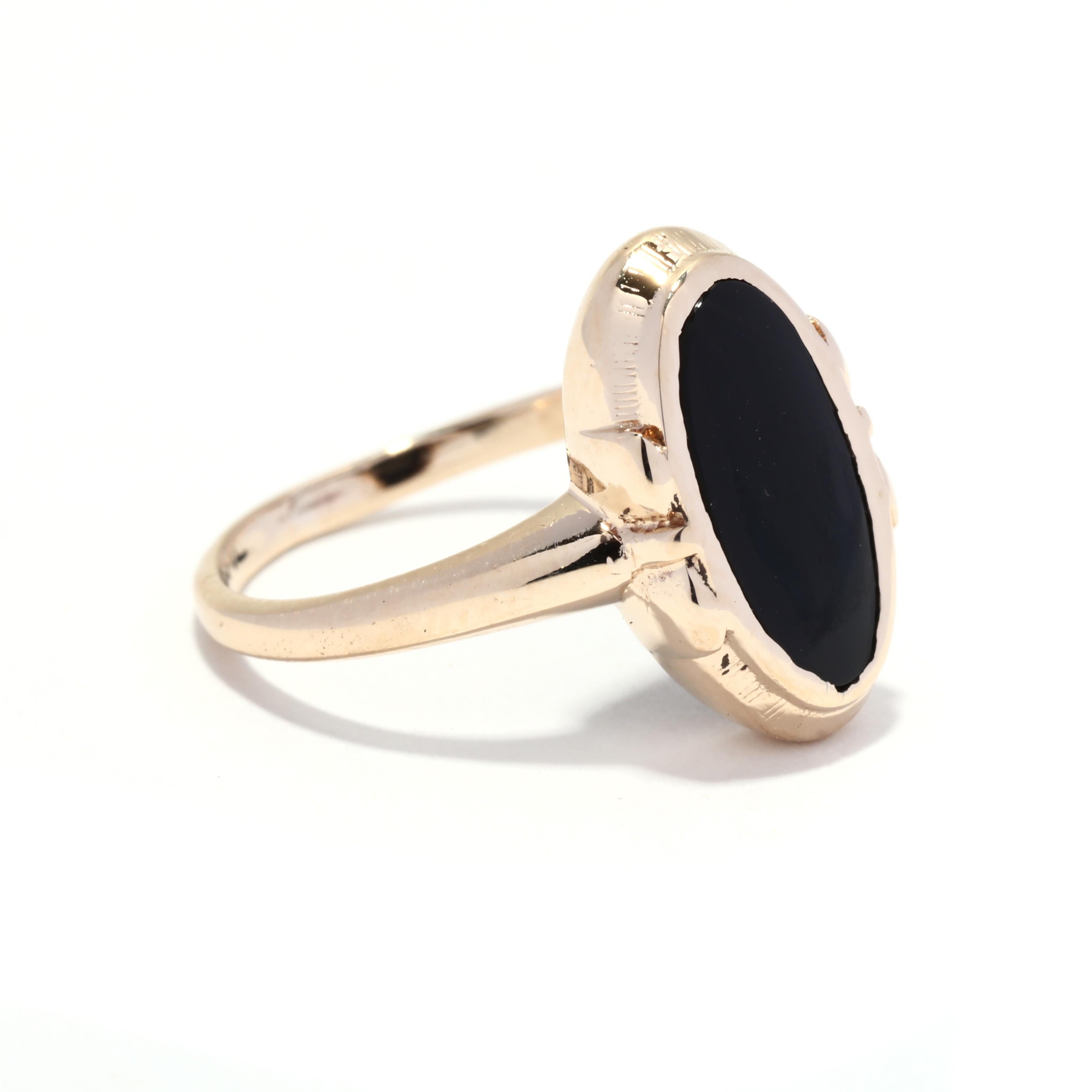 A vintage 10 karat yellow gold black onyx ring. This ring features a bezel set, oblong oval black onyx tablet stone with a bow motif detailing on either side and a thin band.

Stones:
- black onyx, 1 stone
- oval tablet
- 11.5 x5.75 mm

Ring Size