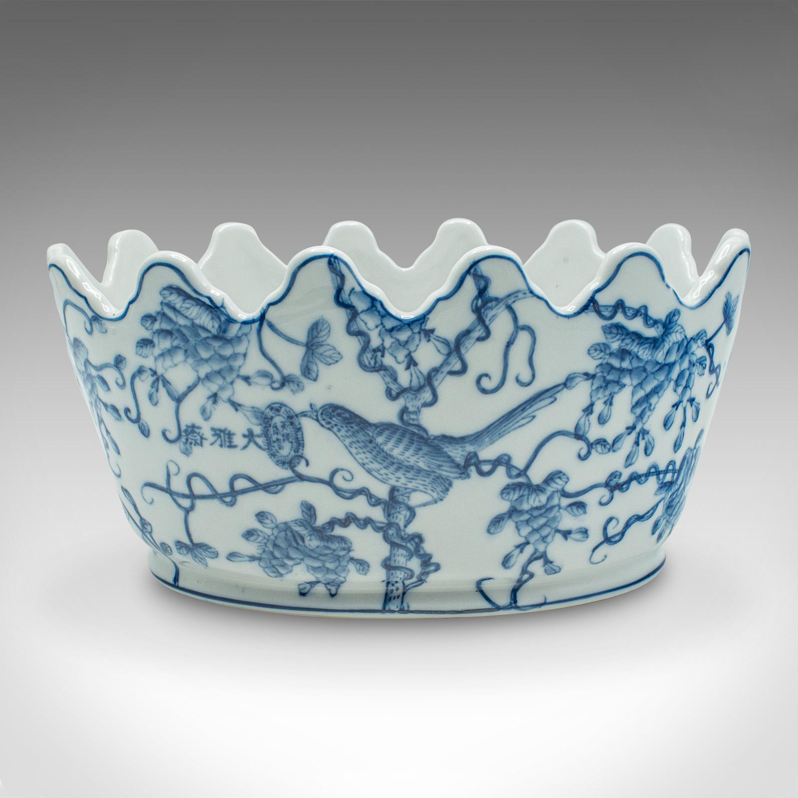 Il s'agit d'une jardinière ovale vintage bleue et blanche. Pot décoratif chinois en céramique, datant de la fin du 20e siècle, vers 1970.

Une forme ondulée fascinante aux proportions généreuses
Présente une patine d'usage désirable et est en bon