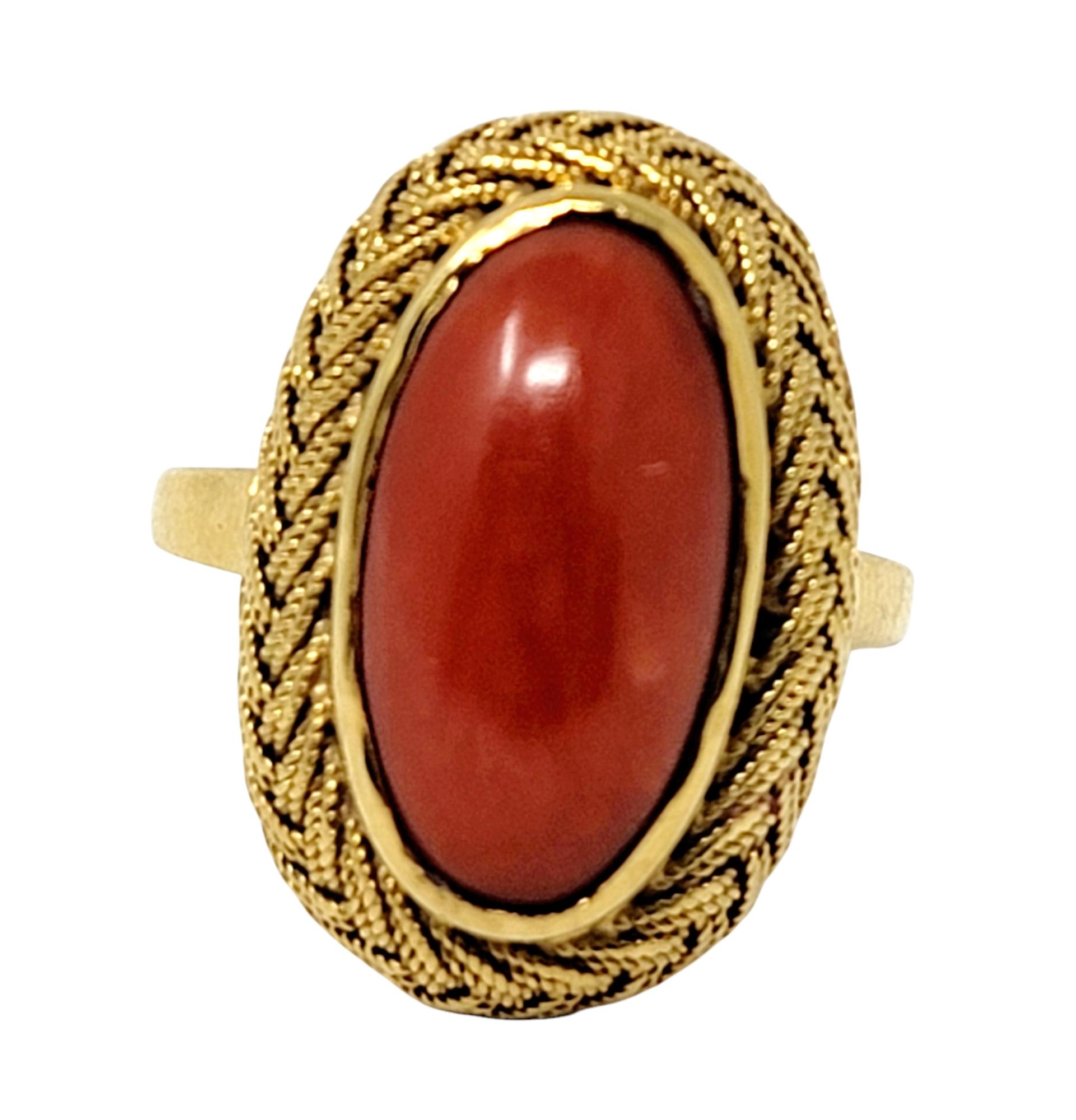 Ring size: 9.75

Elegant vintage cabochon coral ring with an ornate braided 18 karat yellow gold halo. Set in a vertical layout, this beautiful elongated ring flatters and fills the finger. 

Ring size: 9.75
Metal: 18K Yellow Gold 
Weight: 7.13