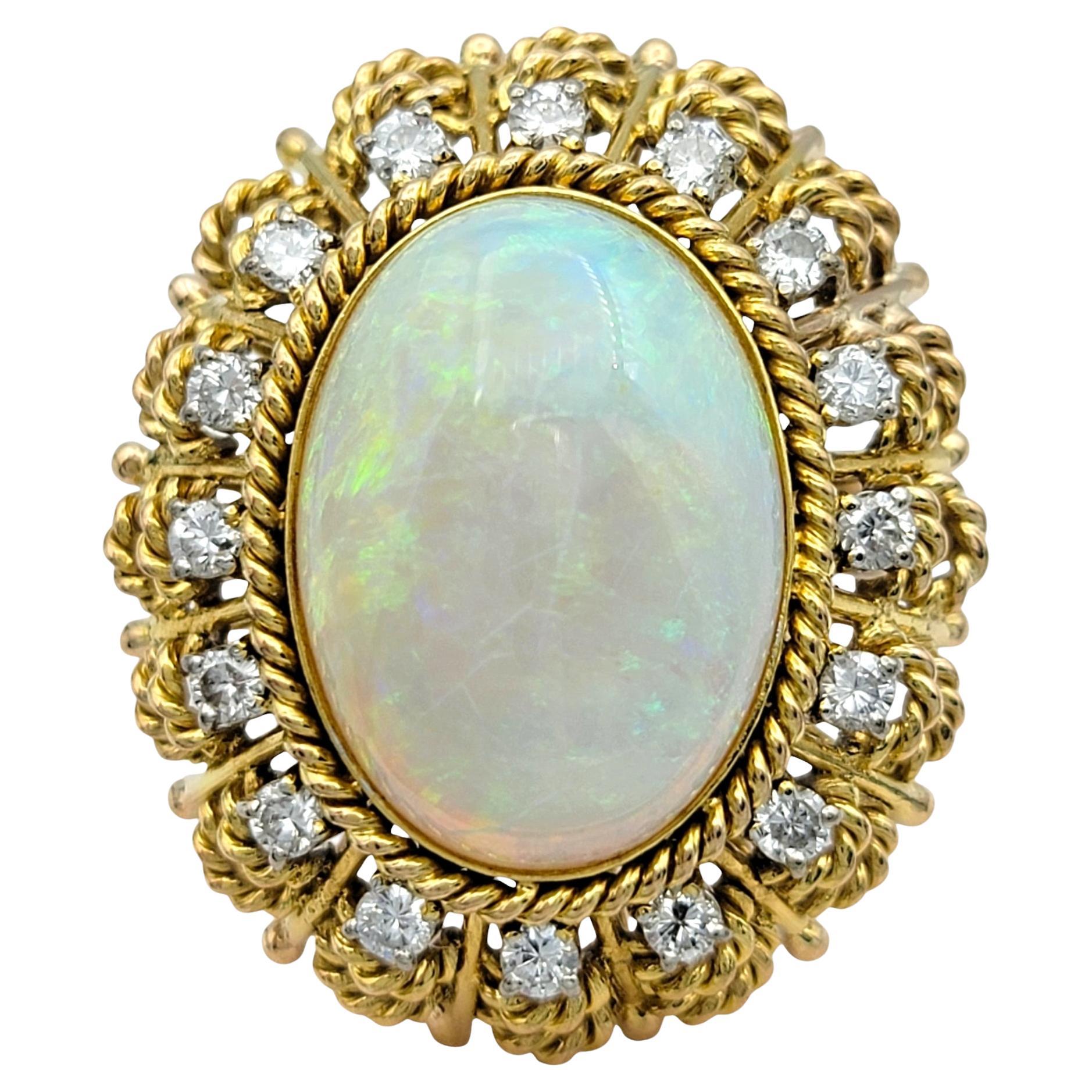 Ring Size: 7 

This stunning opal and diamond ring showcases a captivating design that perfectly blends vibrant color and elegance. The centerpiece of the ring is an eye-catching oval cabochon opal, featuring multiple colors that dance within its