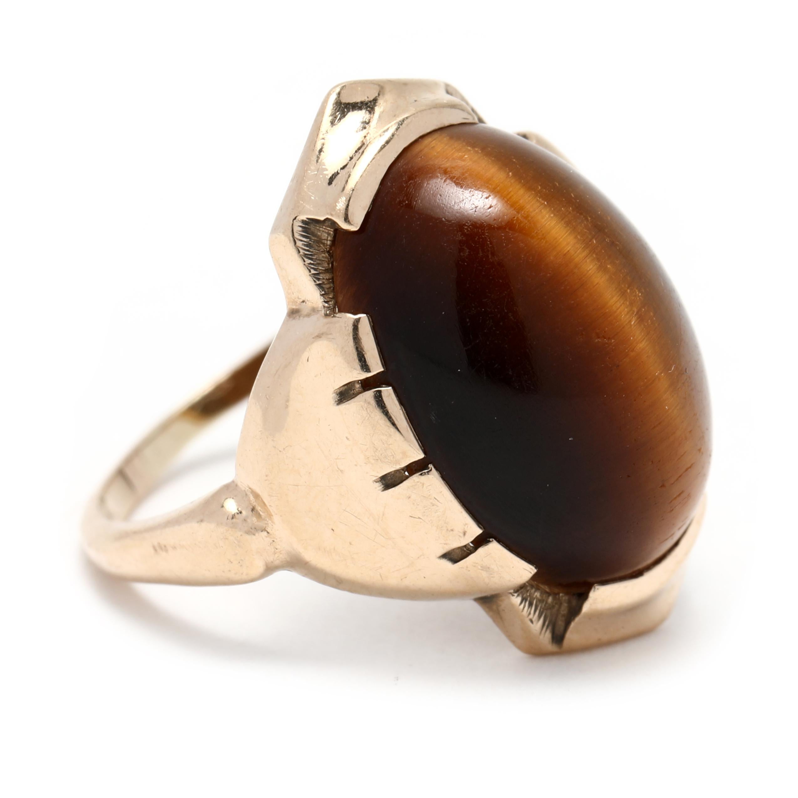 This stunning vintage circa 1930's 10K yellow gold tiger's eye cabochon signet ring is a stunning piece of jewelry. Featuring an oval cabochon tiger's eye stone set in a classic yellow gold band, this stunning piece is sure to turn heads and bring a