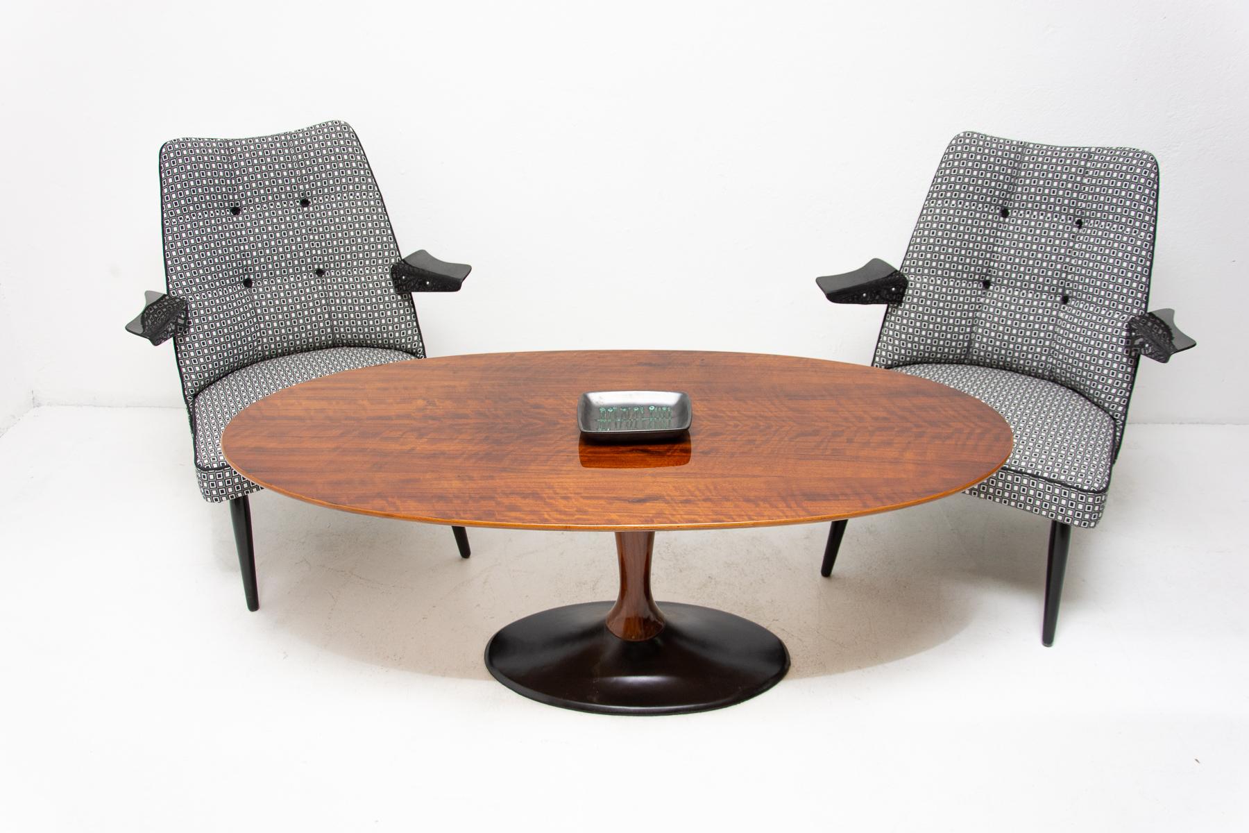 This coffee/occasional table was made in the former Czechoslovakia in the 1970s. The tabletop is in the shape of a long oval and stands on a narrow leg with a pedestal. The table is lacquered to high gloss with a polyurethane. The gross weight of