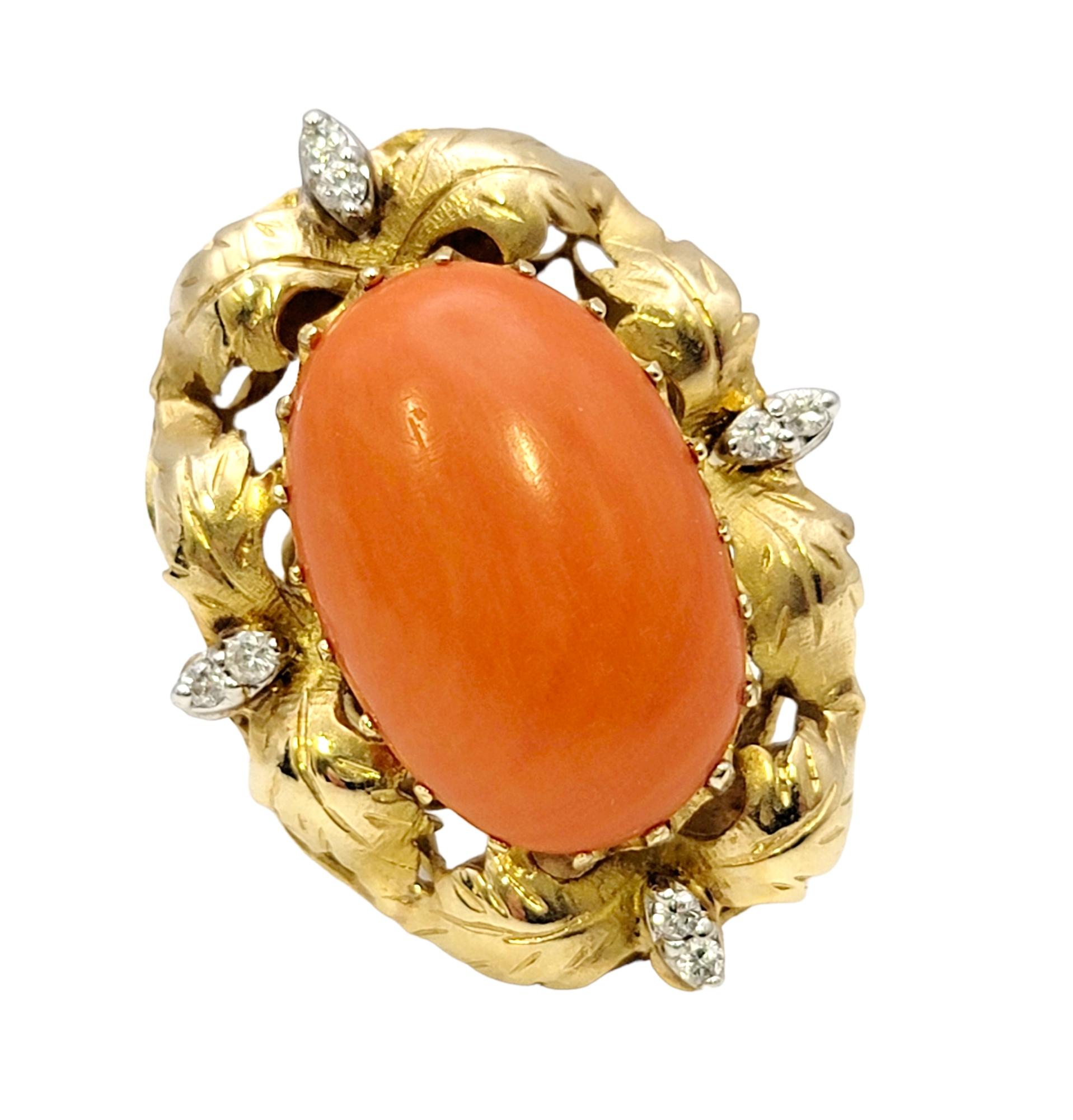 Ring size: 6.5

Featured here is a bold, elegant vintage coral and diamond cocktail ring. The bright orange oval cabochon stone is surrounded by an ornate gold leaf design and accented by several sparkling diamonds to give it an extra touch of