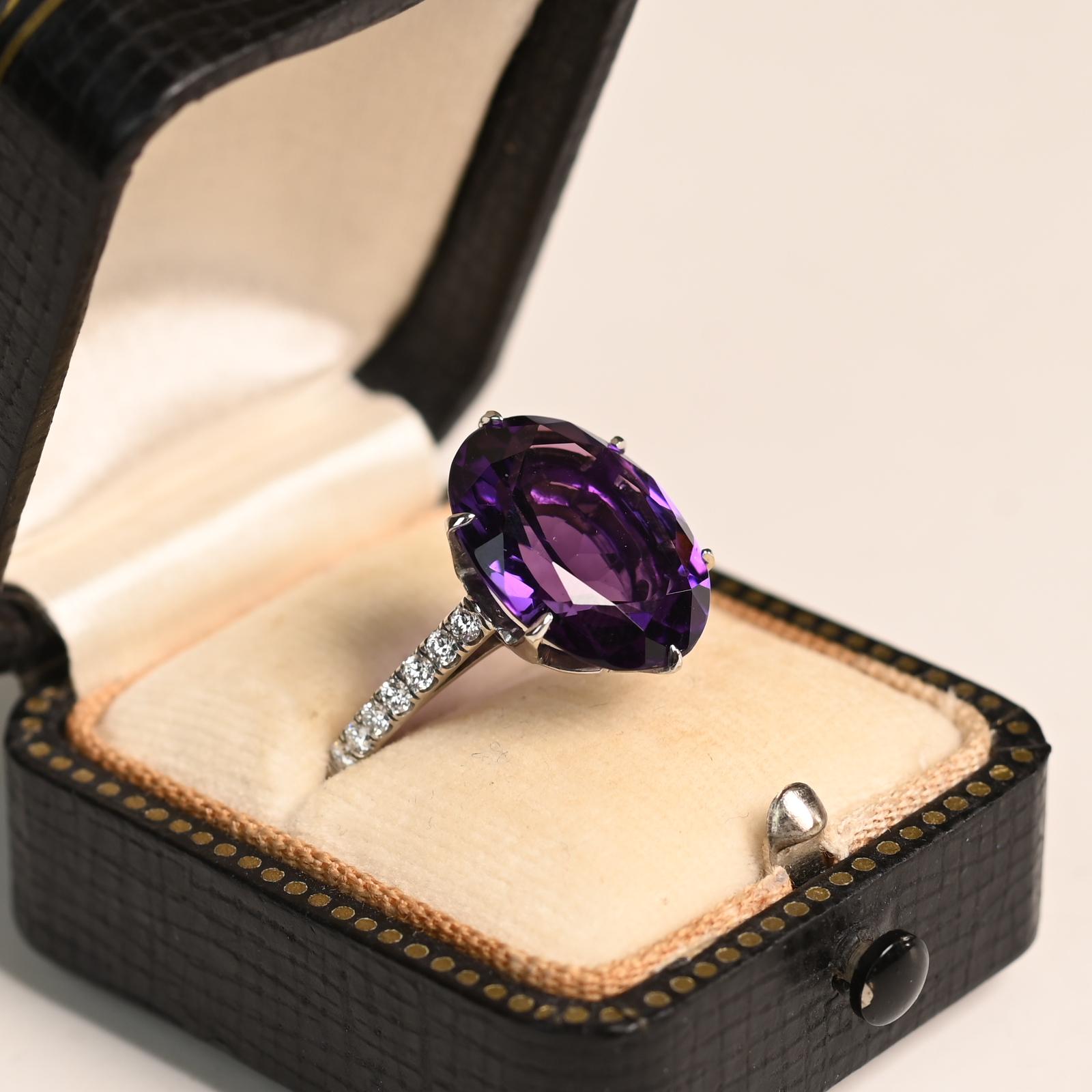 Questo squisito anello di fidanzamento vintage mette in mostra una splendida ametista dal taglio ovale di circa 6,4 carati, incastonata in un lussuoso platino. La tonalità profonda e regale dell'ametista è splendidamente completata dal suo taglio