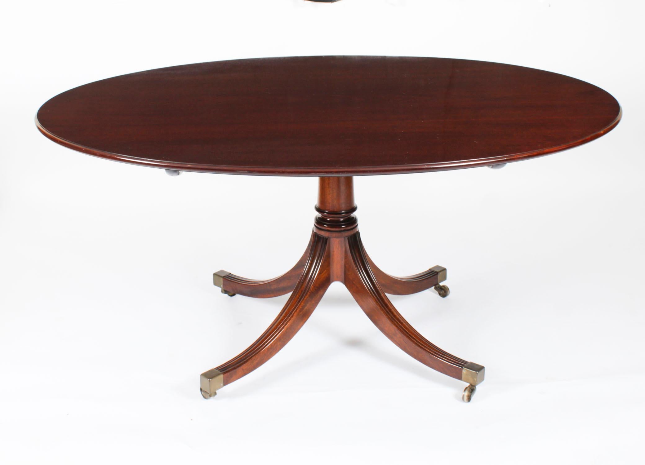 Ce magnifique ensemble de salle à manger comprend une table de salle à manger ovale en acajou flammé de style Sheraton, portant son label sur le dessous, ainsi qu'un ensemble assorti de six chaises de salle à manger à dossier en bouclier, tous