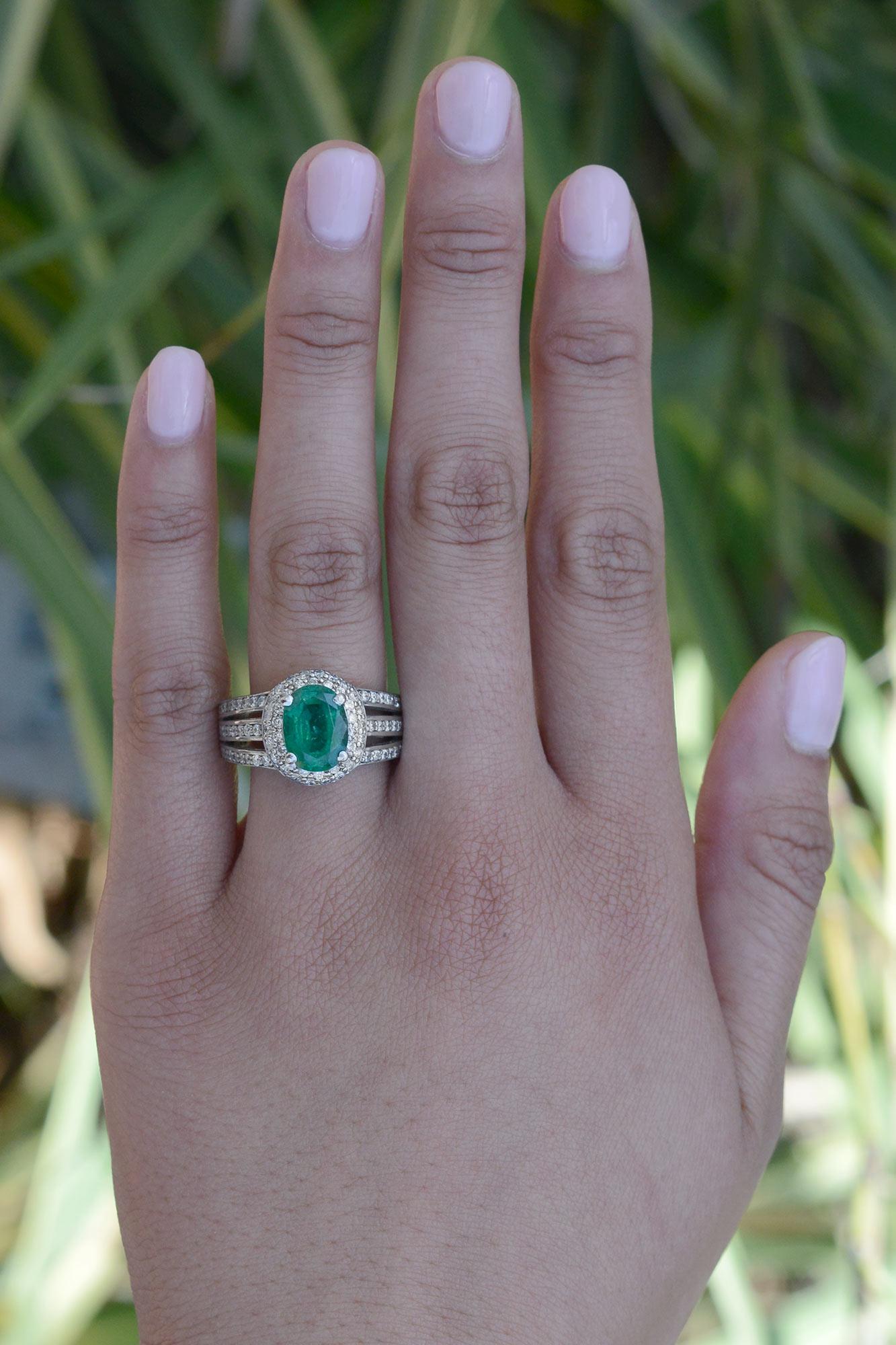 This vintage emerald and diamond engagement ring is a stunning piece of jewelry sure to draw admiration for its lush hue and shimmering diamonds. The wide 3 row diamond band features a prominent and vivid 2.39 carat oval emerald and numerous round