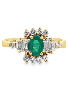 Anello vintage con smeraldo ovale, baguette e diamanti rotondi incastonati in oro giallo 18 carati