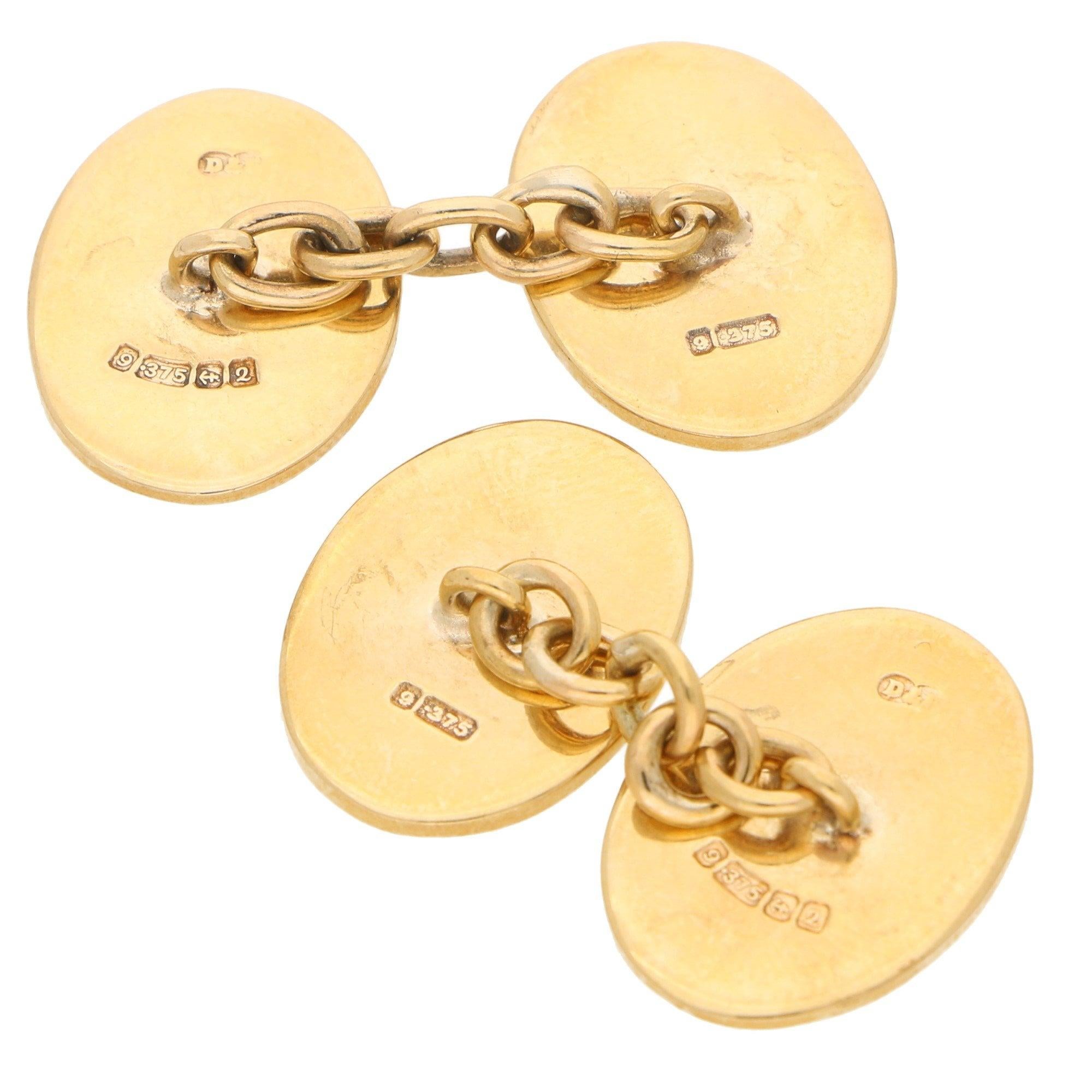 A beautiful pair of vintage oval geometric chain cufflinks set in 9k yellow gold. 

Each cufflink is composed of two terminals, one with a plain face, and the other with a vintage geometric design. The pair are connected by a secure chain link
