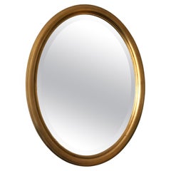 Espejo biselado ovalado vintage de madera dorada Bélgica