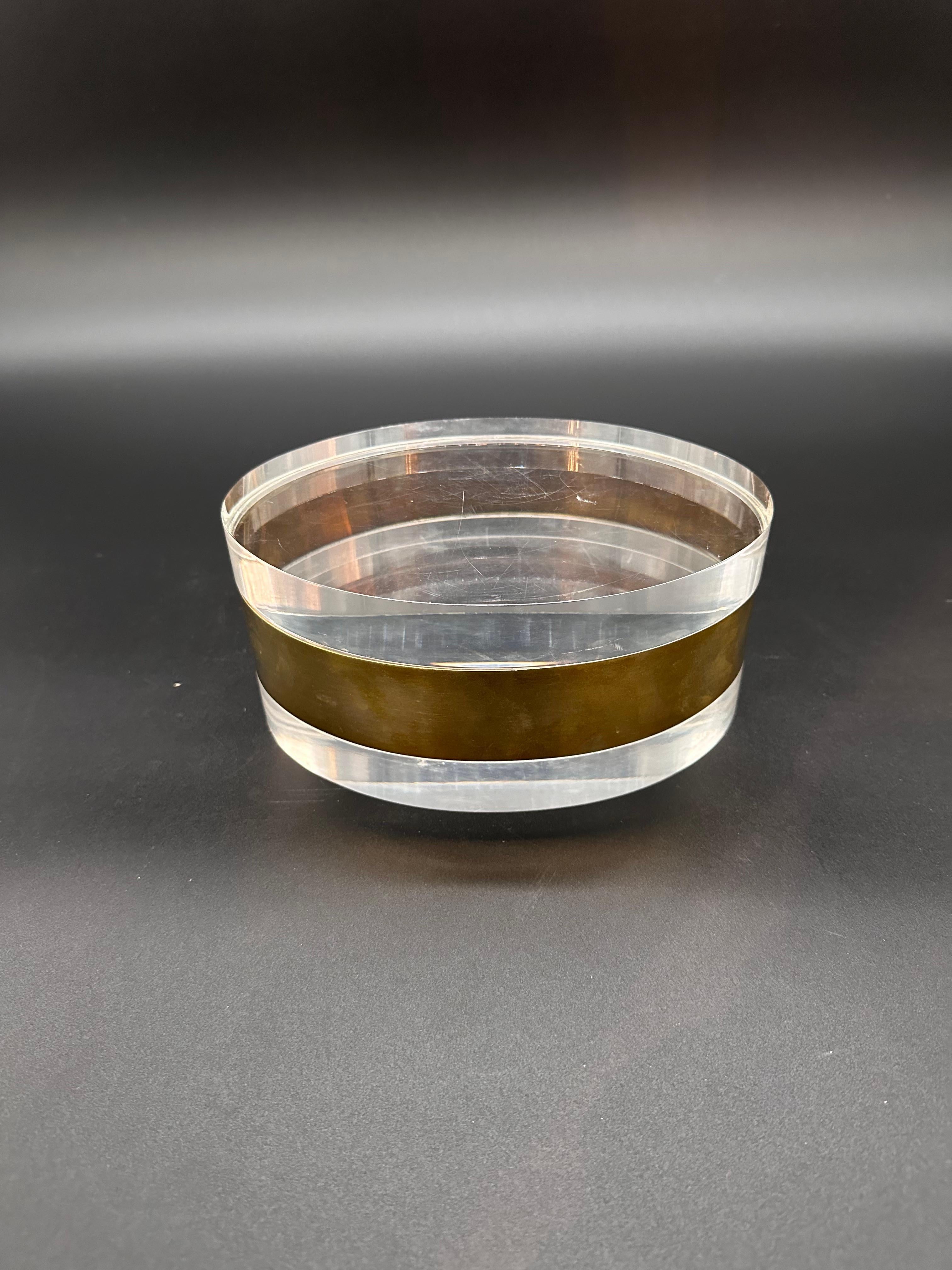 The Vintage Oval Italian Plexiglass and Brass Decorative Box from the 1980s is a captivating blend of elegance and sophistication. Crafted with a combination of luxurious plexiglass and brass, this box showcases the exquisite craftsmanship