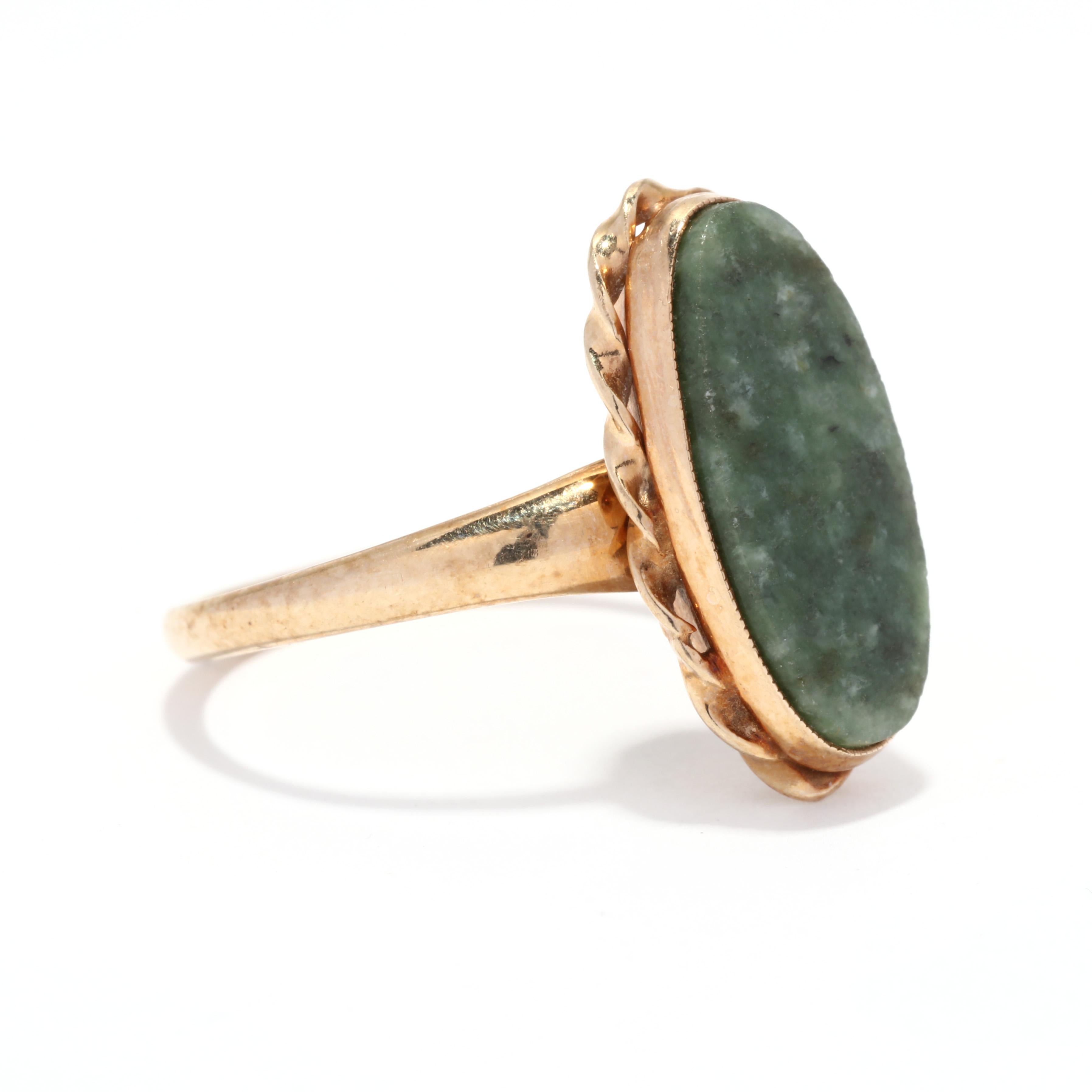 Ein ovaler Nephritring aus 10 Karat Gelbgold. Dieser Ring aus der Mitte des Jahrhunderts zeigt einen ovalen grünen Nephrit im Tablettenschliff, der von einem gedrehten goldenen Ring umgeben ist, und ein sich verjüngendes Band.

Steine:
- nephrit, 1